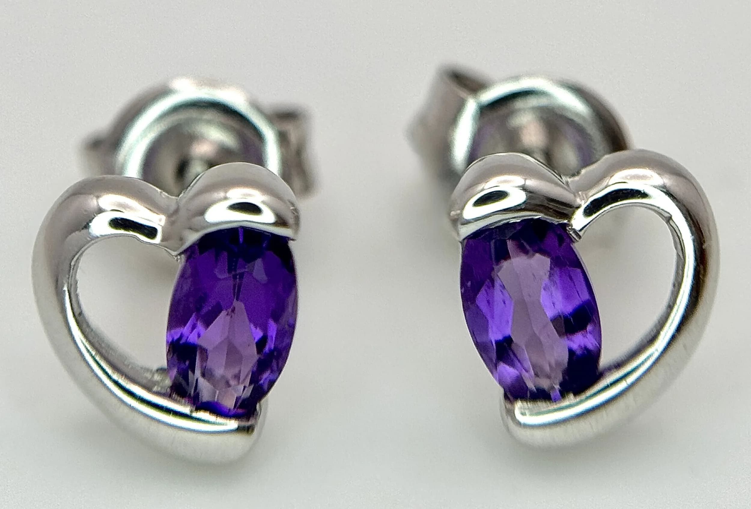 A Pair Of 9K White Gold, Amethyst Set, Heart Stud Earrings. 1.1G. Sc 4045