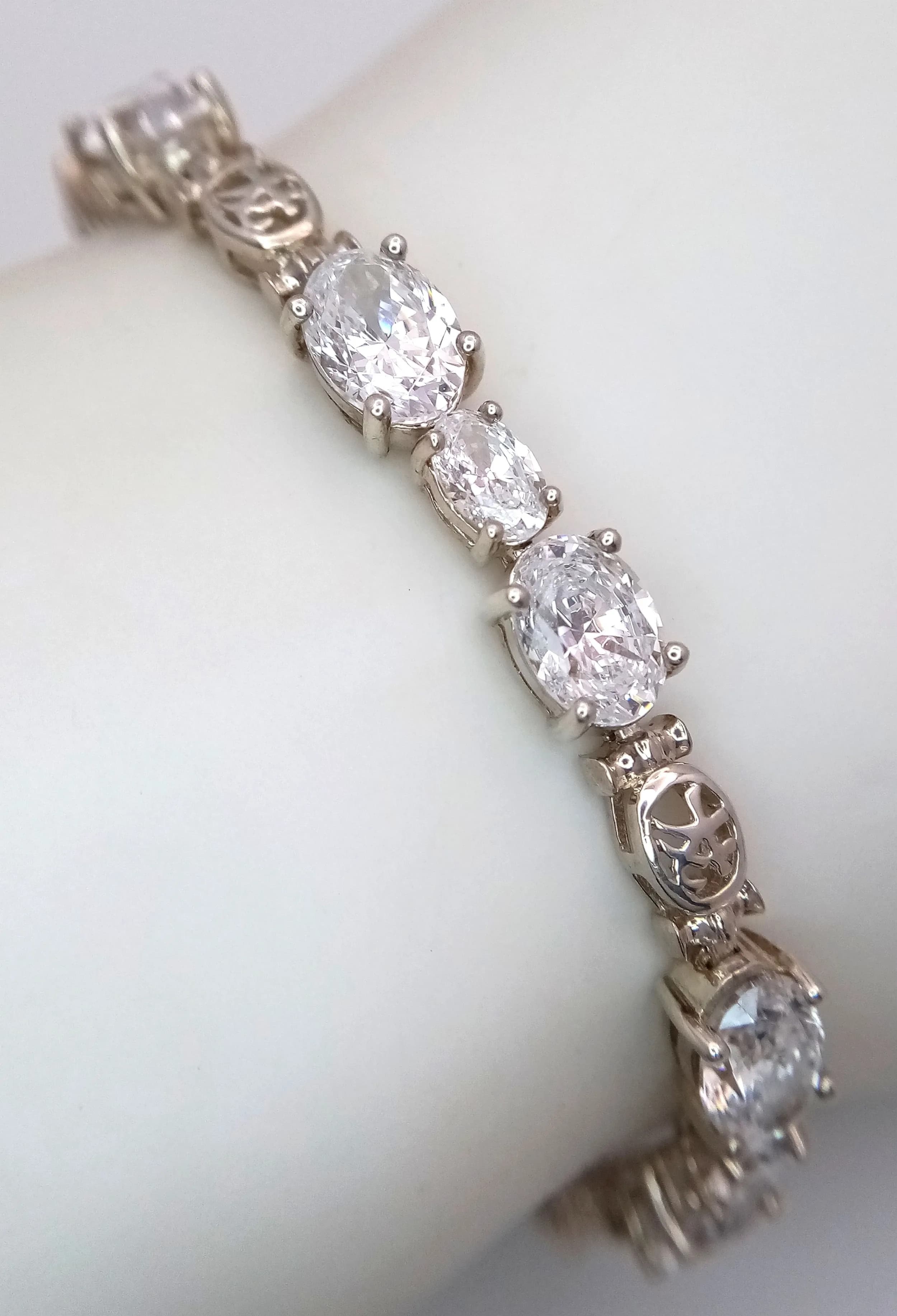 A Sterling Silver and Diamonique Cubic Zirconia Tennis Bracelet-19cm Length. 7mm Wide and has a gross weight of 15.96 grams. Set with 7 & 5mm Oval Cut Diamonique Cubic Zirconia.