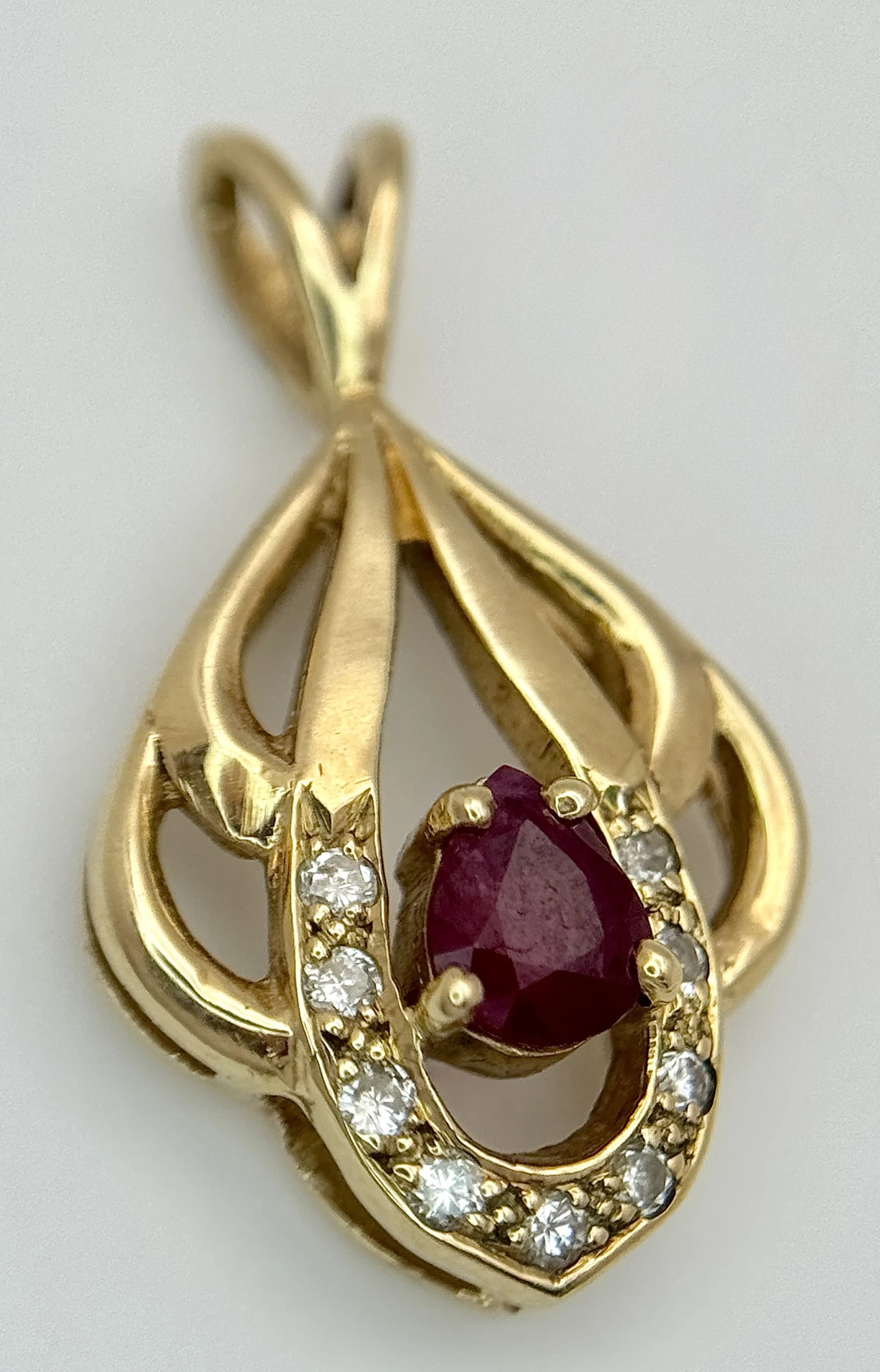 A 9K Yellow Gold, Ruby and Diamond Pendant in Decorative openwork. 2cm. 1.6g.