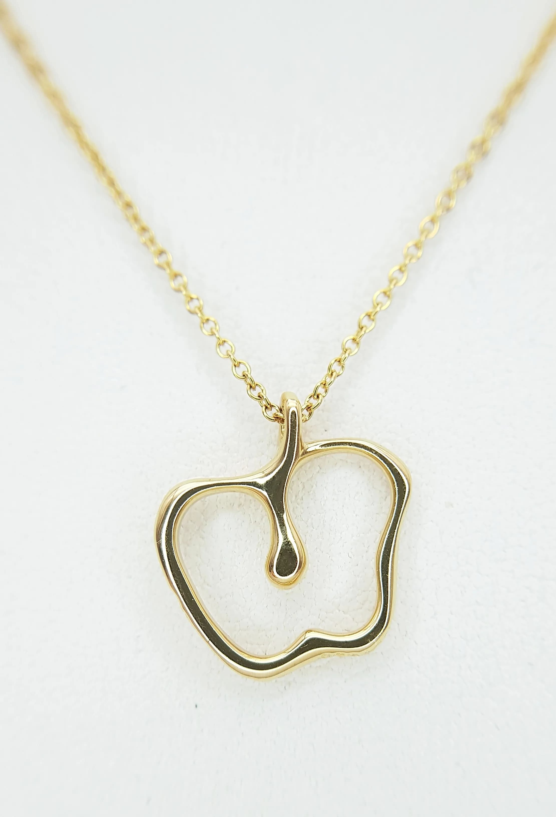 A Tiffany and Co, 18K Gold (Peretti) Apple Pendant on a Tiffany and Co. 18K Gold Chain Necklace. 15mm pendant. 40cm chain. 3.4g total weight. Comes with a Tiffany pouch. TTB042