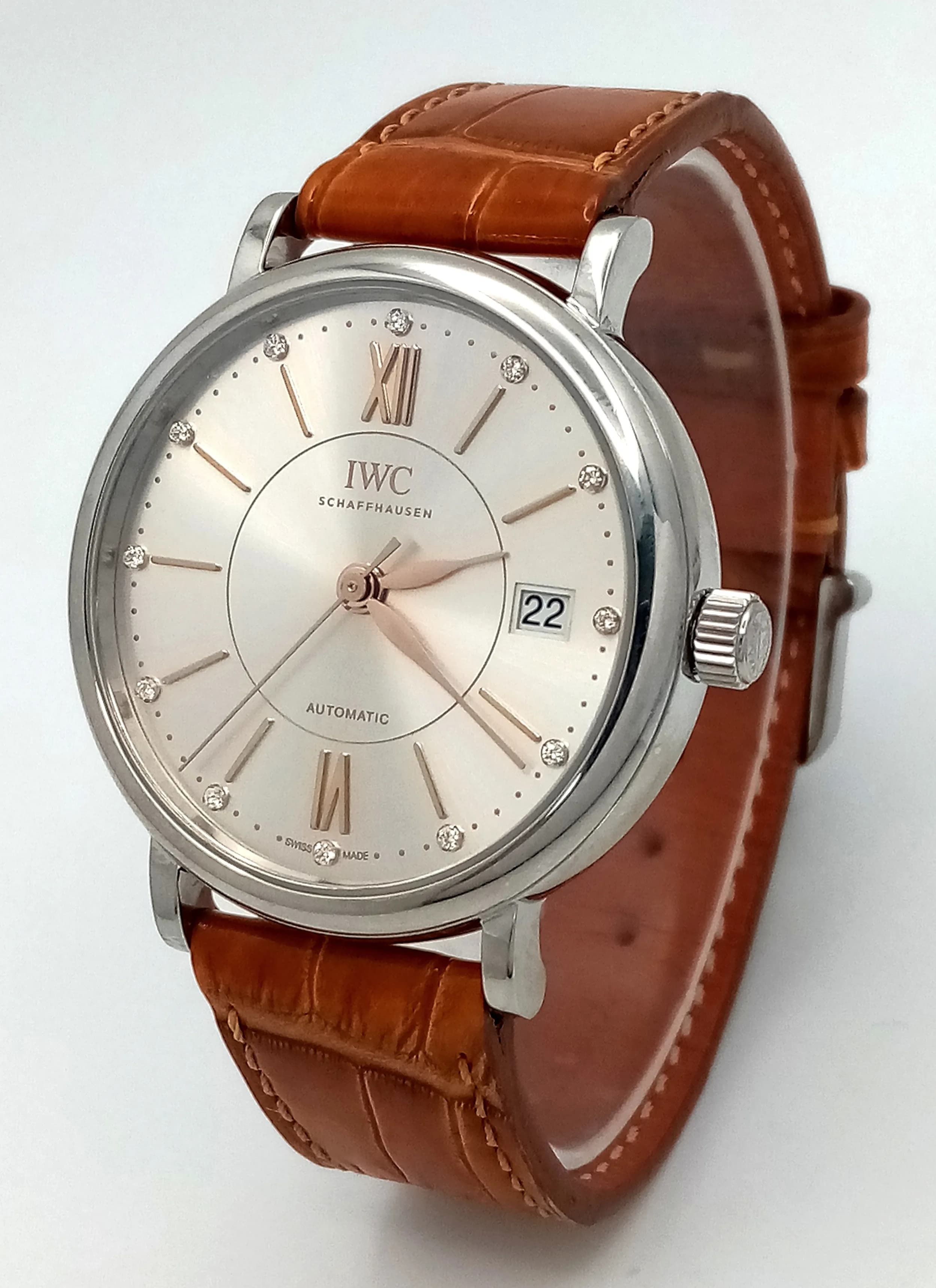 An IWC (International Watch Company) Portofino Diamond Gents Automatic Watch. Tan leather strap. Stainless steel case - 37mm. Silver tone dial with Roman numerals and diamond markers. In good condition and working order. Comes with a warranty card. TTB010.