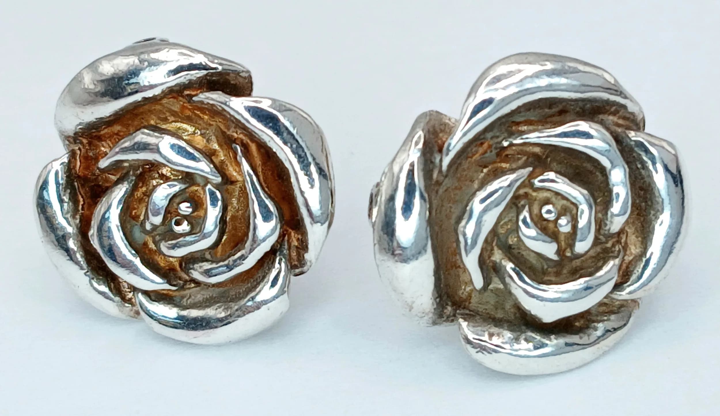 A Lovely Pair of 925 Silver Rose Stud Earrings. Designed as rose flower heads with polished silver petal detail. Approx 1.5cm diameter. Total weight 5.26 grams.