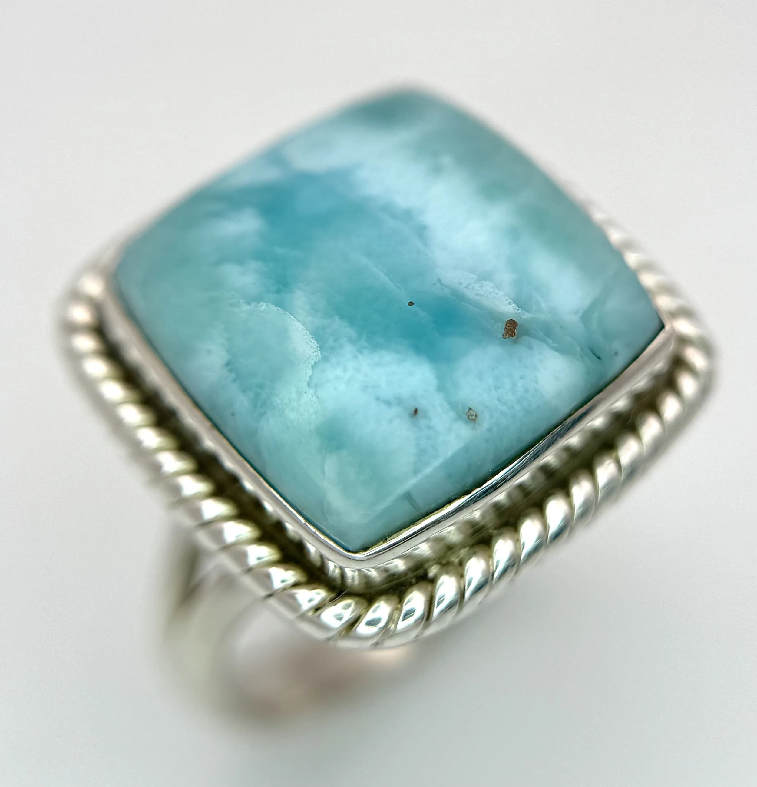 A Sterling Silver Blue Larimar Set Ring Size R. The Ring is set with a Cushion Cut 1.8cm Square Blue Larimar and has a gross weight of 7.67 grams