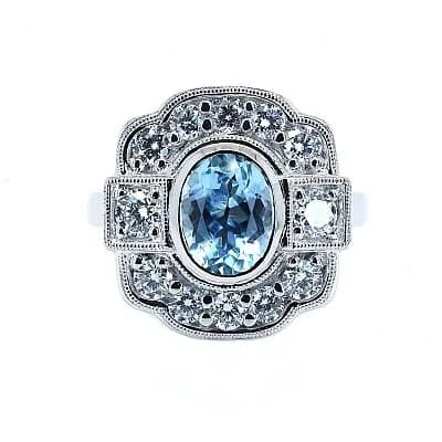 A Platinum Oval Cut Aquamarine and Diamond Ring. Centre Aquamarine Weighing 1.10ct, surrounded by Diamonds Weighing Total 0.85ct. Total Ring Weight 9.72g, Size M 1/2. Ref: 017807