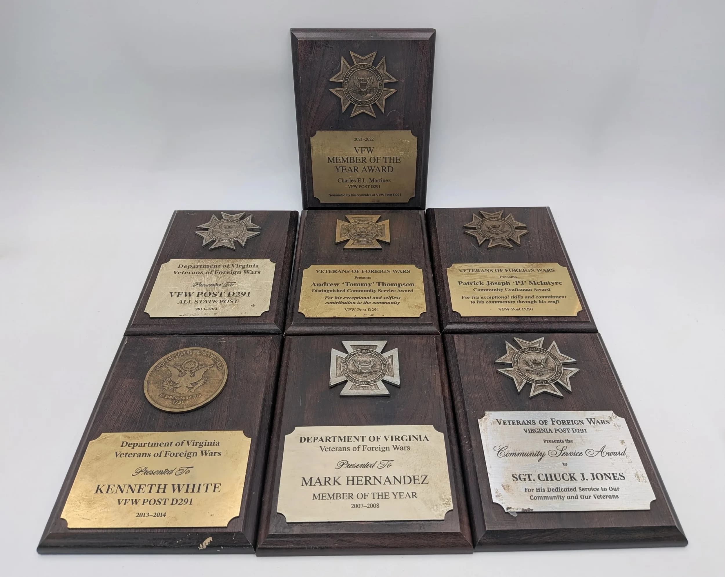 Seven USA Veterans of Foreign Wars Award Plaques. Different awards featuring wood bases, with metal descriptive plates and bronze/white metal star-shaped medallions. 15 x 21cm.