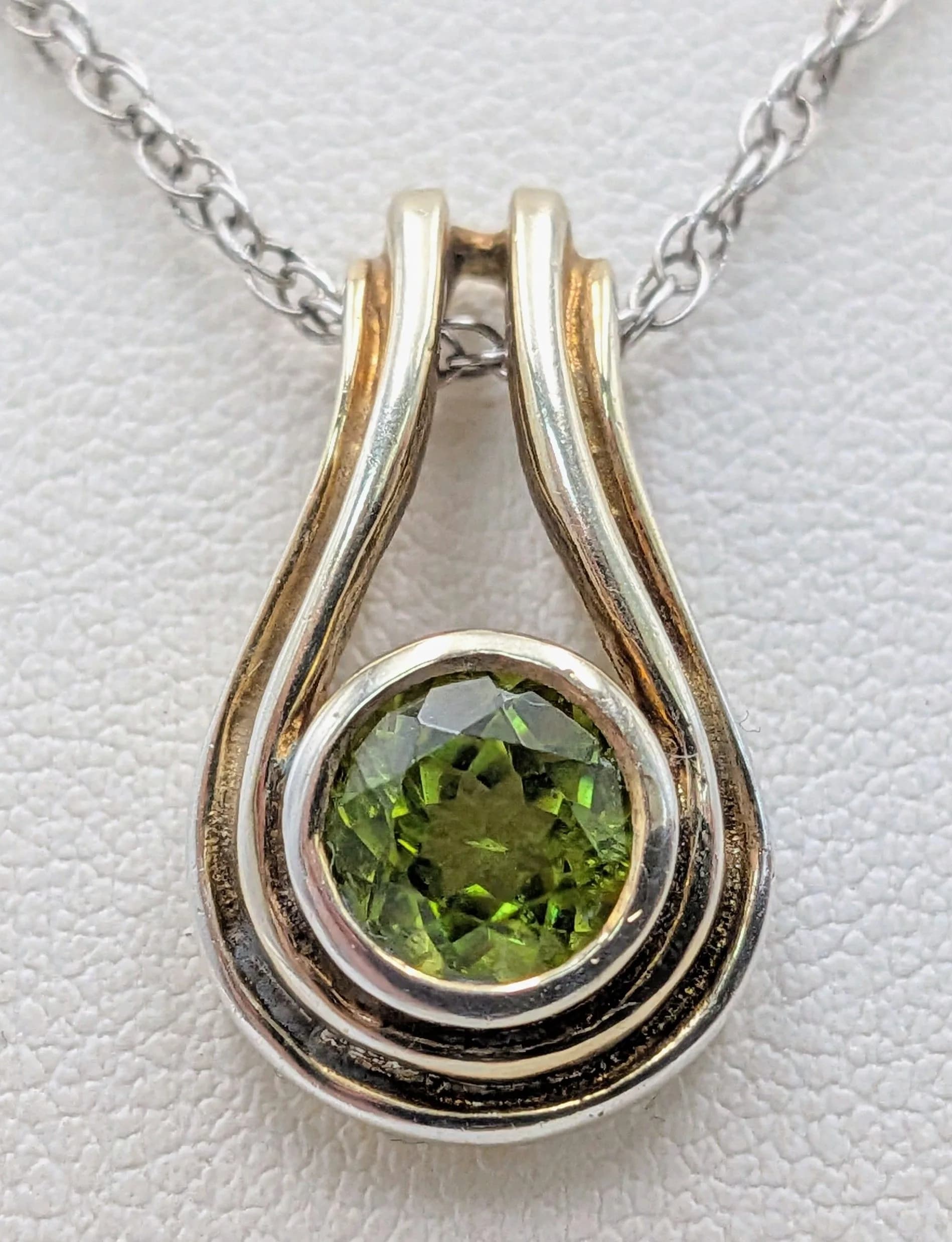 A fancy 925 gilded silver Peridot pendant, set on a silver necklace. Total weight 4.9G. Total length 54cm.
