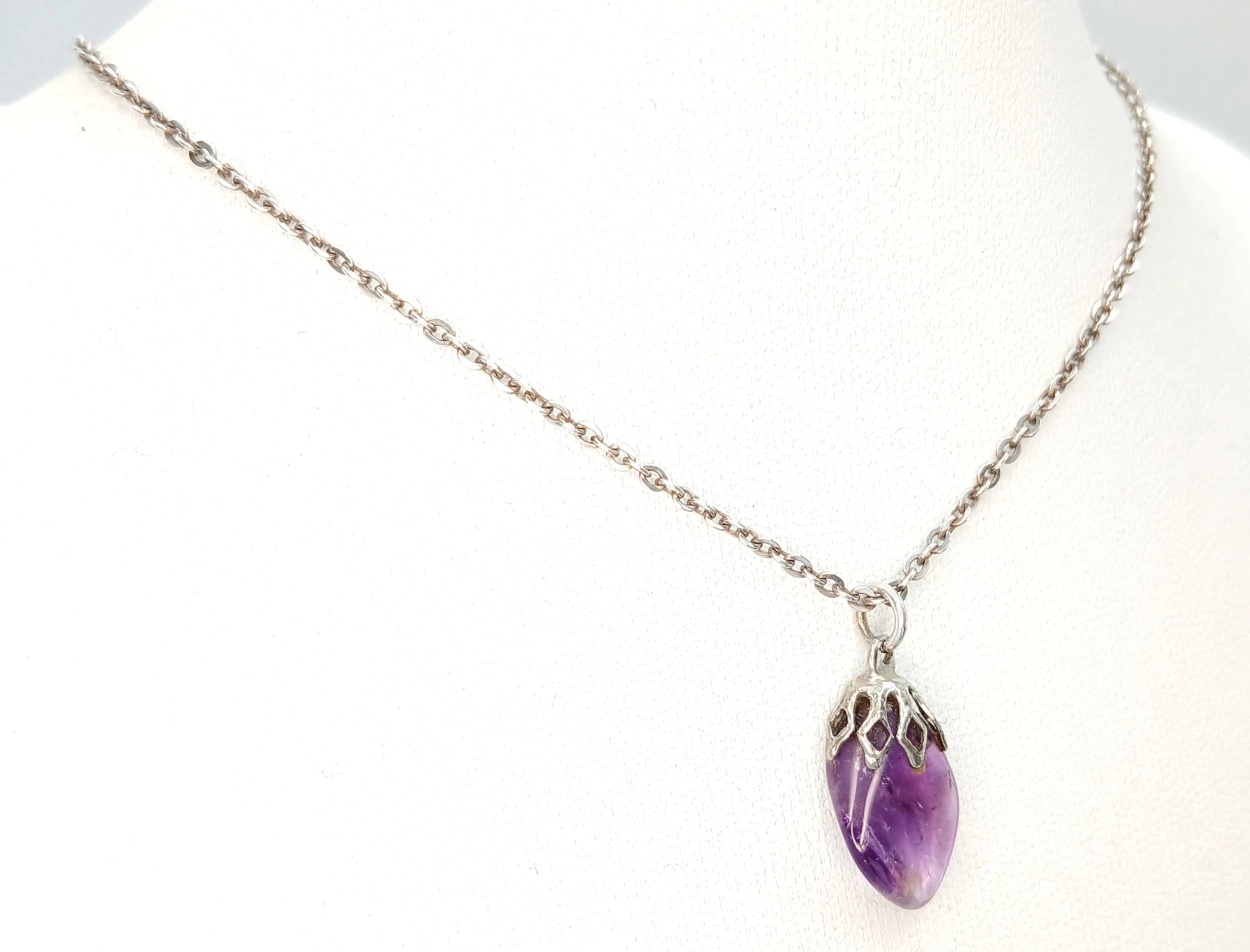 A Charming 925 Sterling Silver Amethyst Set Pendant Necklace. The necklace is set with a pear-shaped amethyst drop, within an openwork silver mount. The necklace measures 40cm length. The pendant measures 2cm drop. The necklace has a gross weight of 3.43 grams.