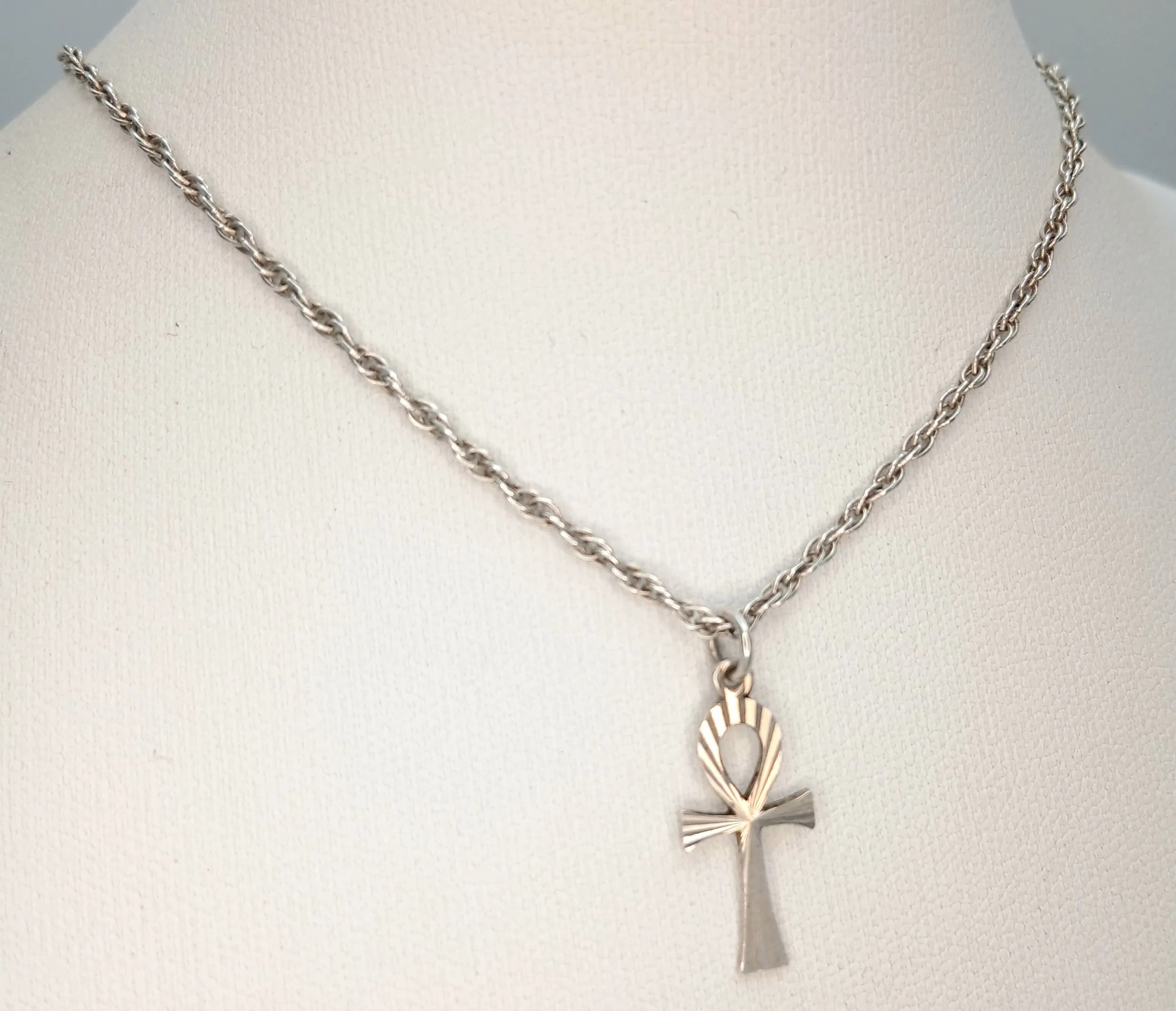 A Pretty 925 Sterling Silver Ankh Cross Pendant Necklace. The pendant features an ankh cross-shaped decorative silver design. The necklace measures 40cm length. The pendant measures 1.5cm drop. Gross weight of necklace is 3.23 grams.