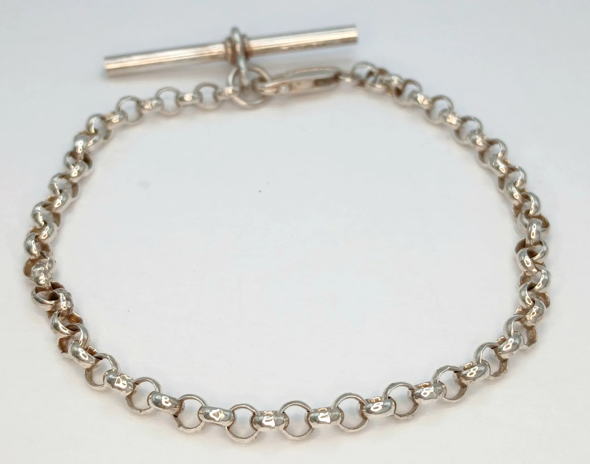A Stylish 925 Sterling Silver T-Bar Bracelet - 17cm Length. Features a curb link chain with a polished T-bar fastening. Gross weight 6 grams.