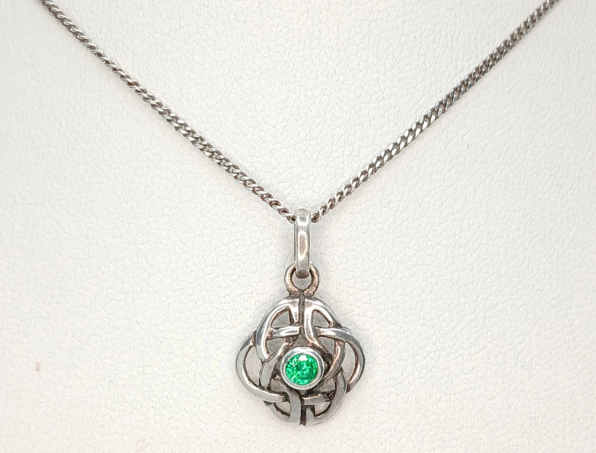 A Beautiful 925 Sterling Silver Green Stone Celtic Knot Pendant Necklace - 40cm Length. Features an openwork Celtic knot pendant set with a round green stone on a fine silver chain. The pendant measures 1.2cm x 1.2cm. Gross weight 2.96 grams.