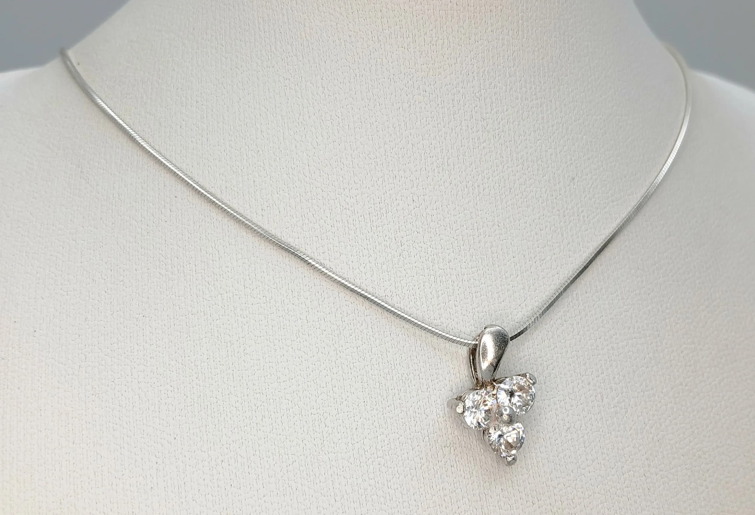 A Stunning Italian 925 Sterling Silver CZ Set Three Stone Pendant Necklace - 40cm Length. Features a three round CZ stone set cluster pendant on a fine silver snake chain. The pendant measures 1.5cm x 1cm. Gross weight 4.18 grams.