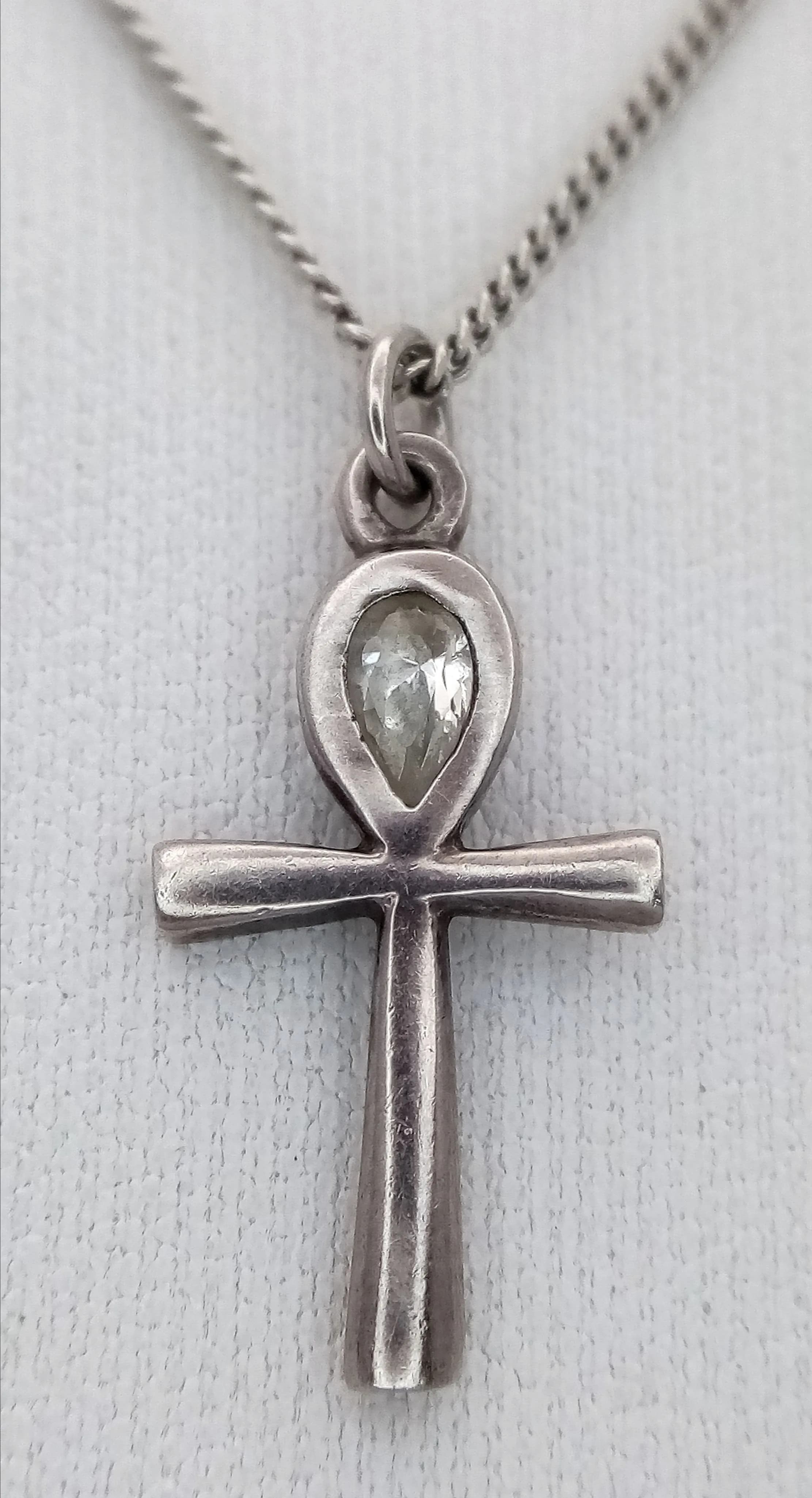 A Lovely 925 Sterling Silver CZ Set Ankh Pendant Necklace - 42cm Length. Features an ankh cross pendant set with a pear-shaped CZ stone on a fine silver chain. The pendant measures 1.7cm x 1cm. Gross weight 3.07 grams.