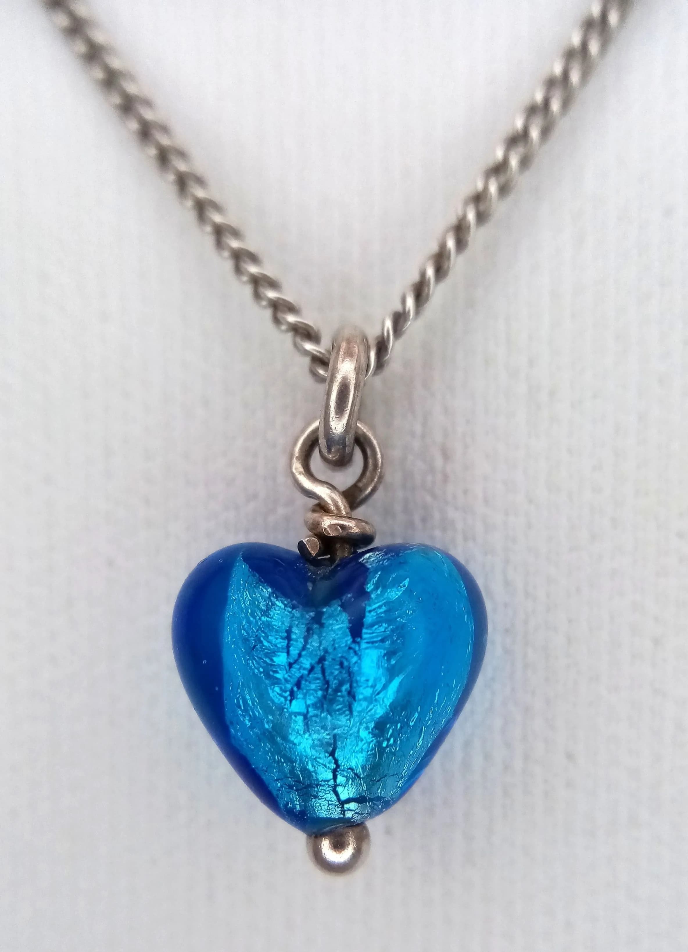 A Pretty 925 Sterling Silver Blue Stone Heart Pendant Necklace - 46cm Length. Features a blue stone heart drop pendant on a fine silver chain. The pendant measures 1cm x 1cm. Gross weight 3.42 grams.