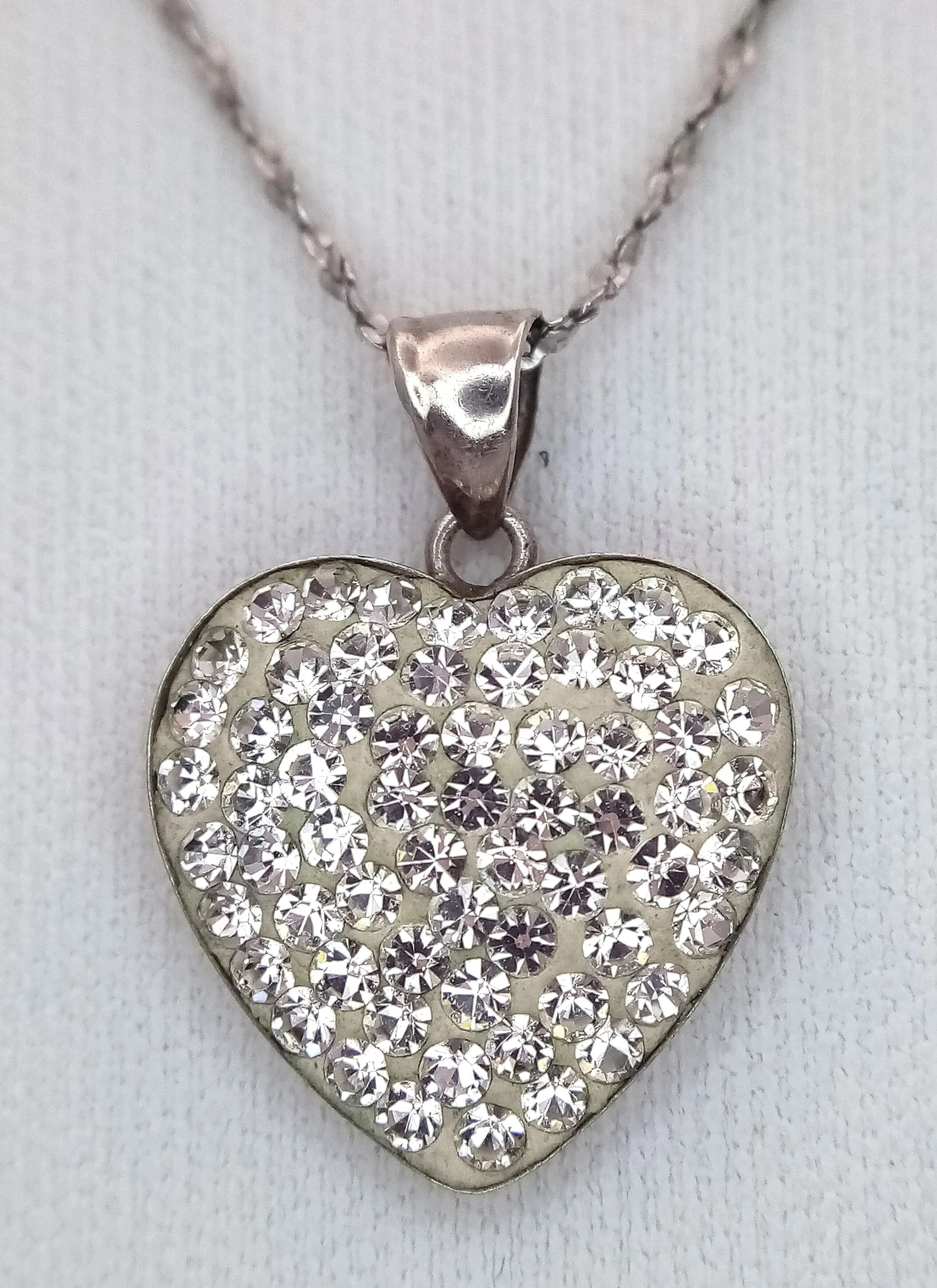 A Stunning 925 Sterling Silver White Stone Set Heart Pendant Necklace - 46cm Length. Features a pavé set heart pendant on a fine silver chain. The pendant measures 1.5cm x 1.5cm. Gross weight 2.81 grams.