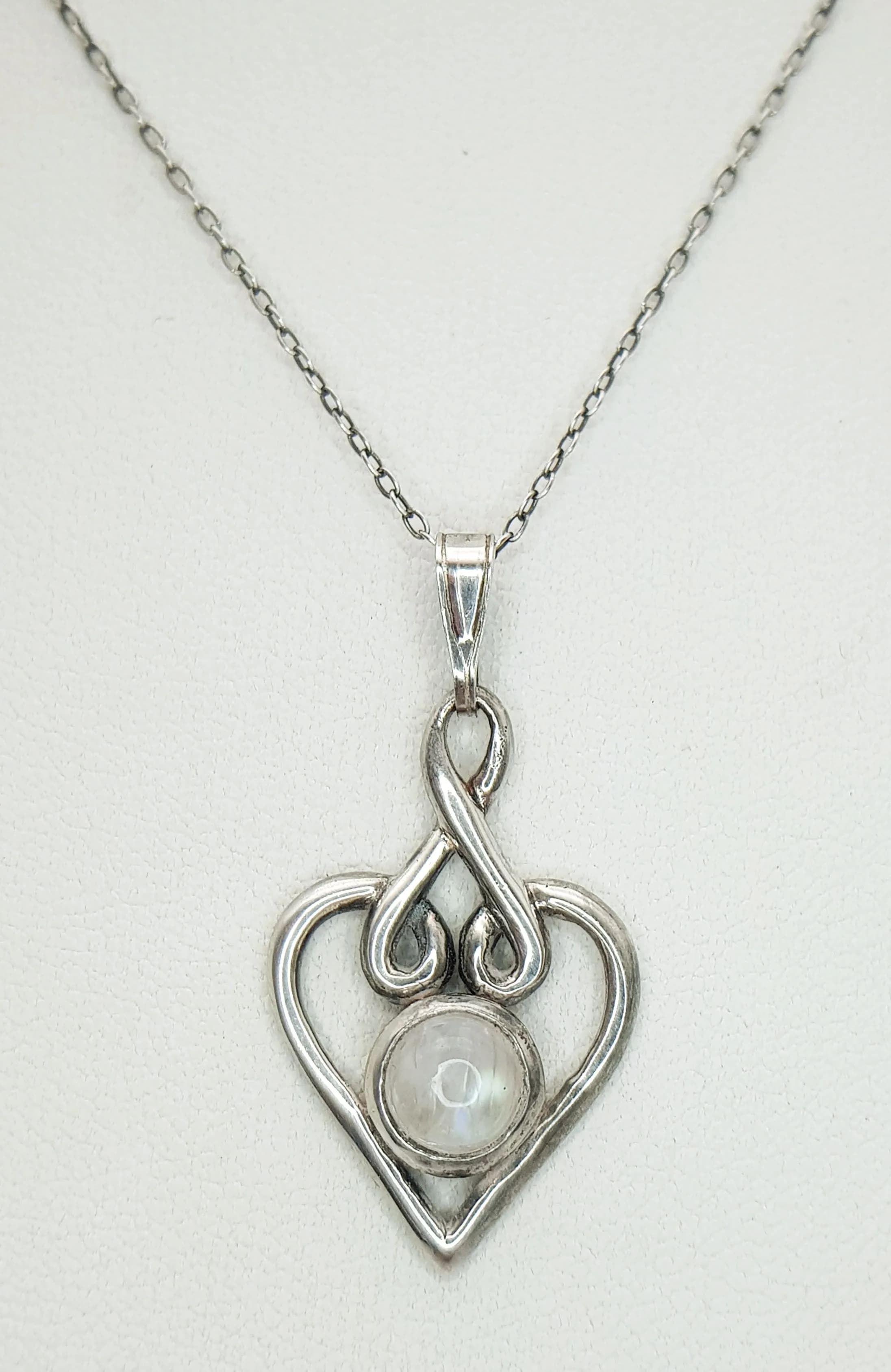 A Pretty 925 Sterling Silver Moonstone Heart Pendant Necklace - 40cm Length. Features an openwork heart pendant set with a round cabochon moonstone on a fine silver chain. The pendant measures 1.5cm x 2.5cm. Gross weight 3.58 grams.