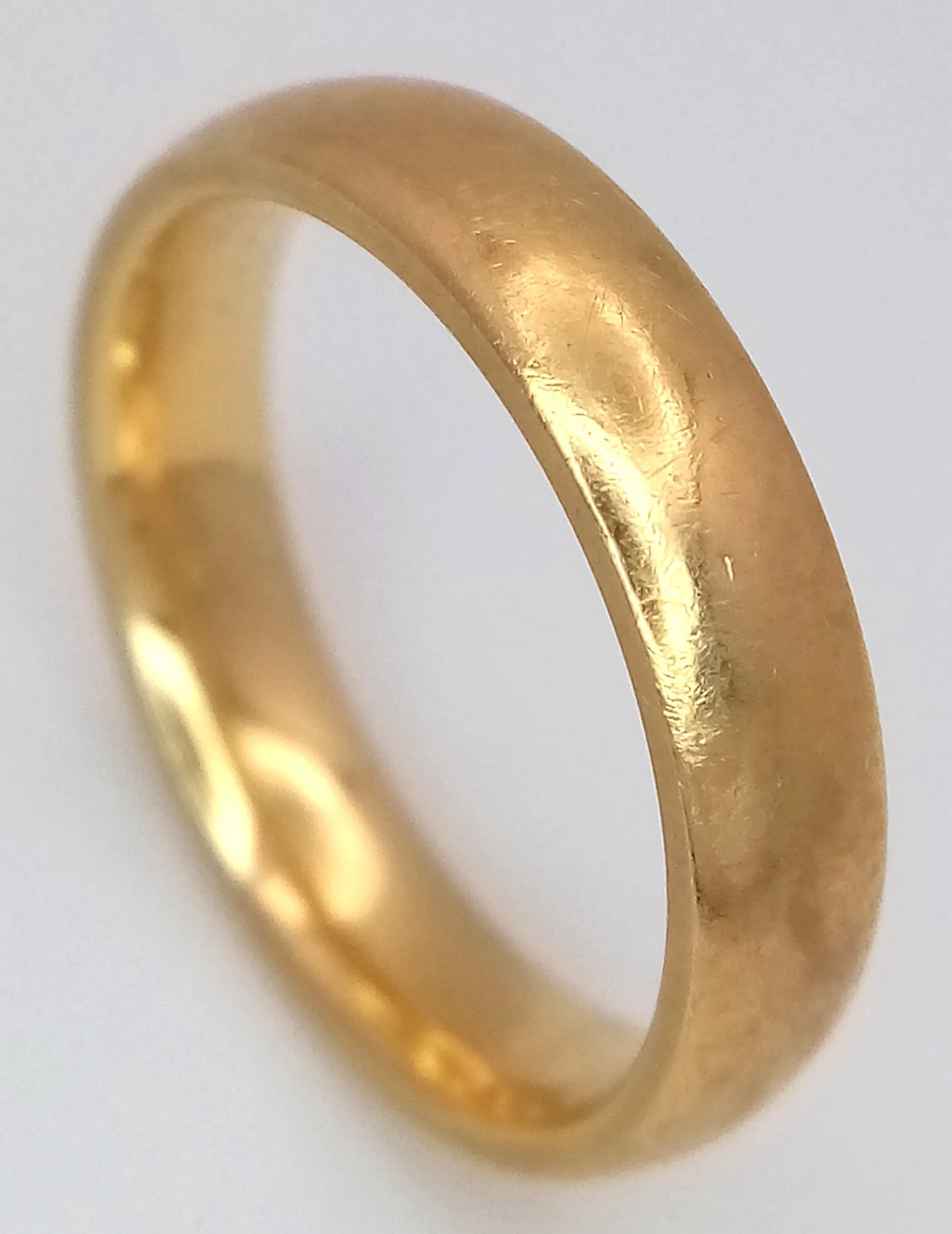 An 18K Yellow Gold Band Ring. 5mm width. Size K 1/2. 5.35g. Full UK hallmarks.