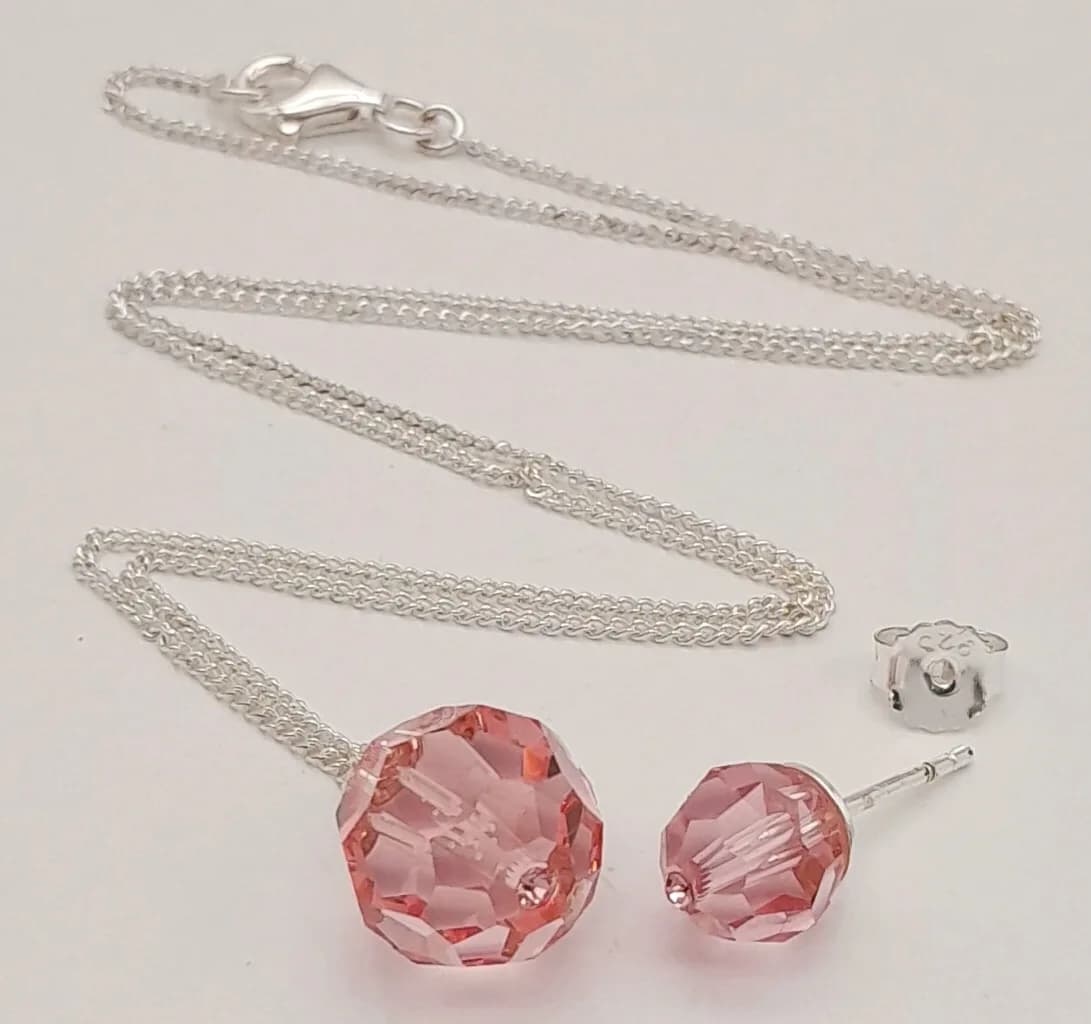A 925 Silver Necklace with Pink faceted crystal Stone Pendant and Matching 925 Silver Earring. Approx 42cm chain length. Total weight: 5.25g. Comes with a presentation box. Please see photos for details.
