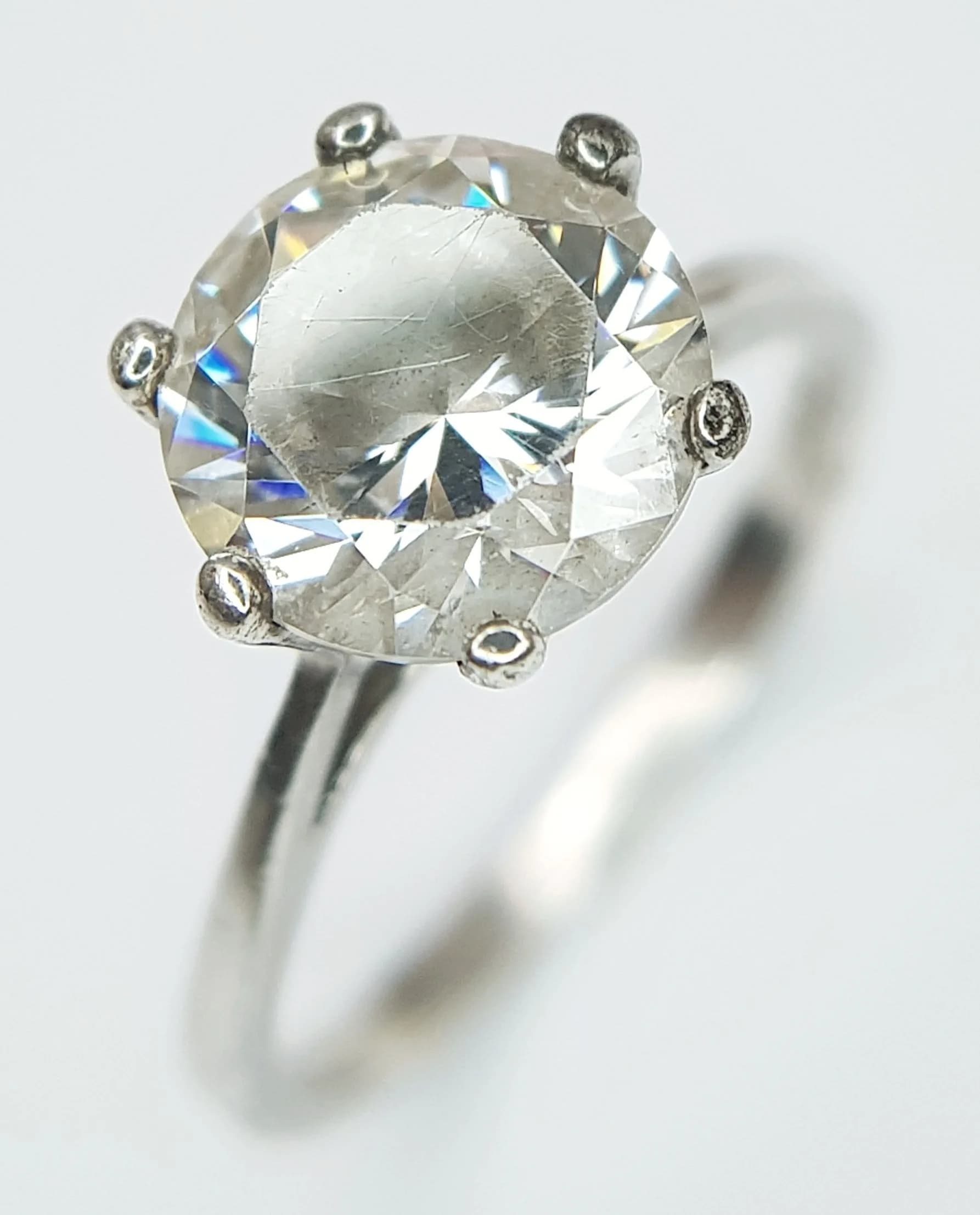 A Stunning 925 Silver CZ Solitaire Ring. Size J. Features a round CZ stone in a raised claw setting with split shoulders. The CZ stone measures 0.8cm diameter. Gross weight 2.29 grams.