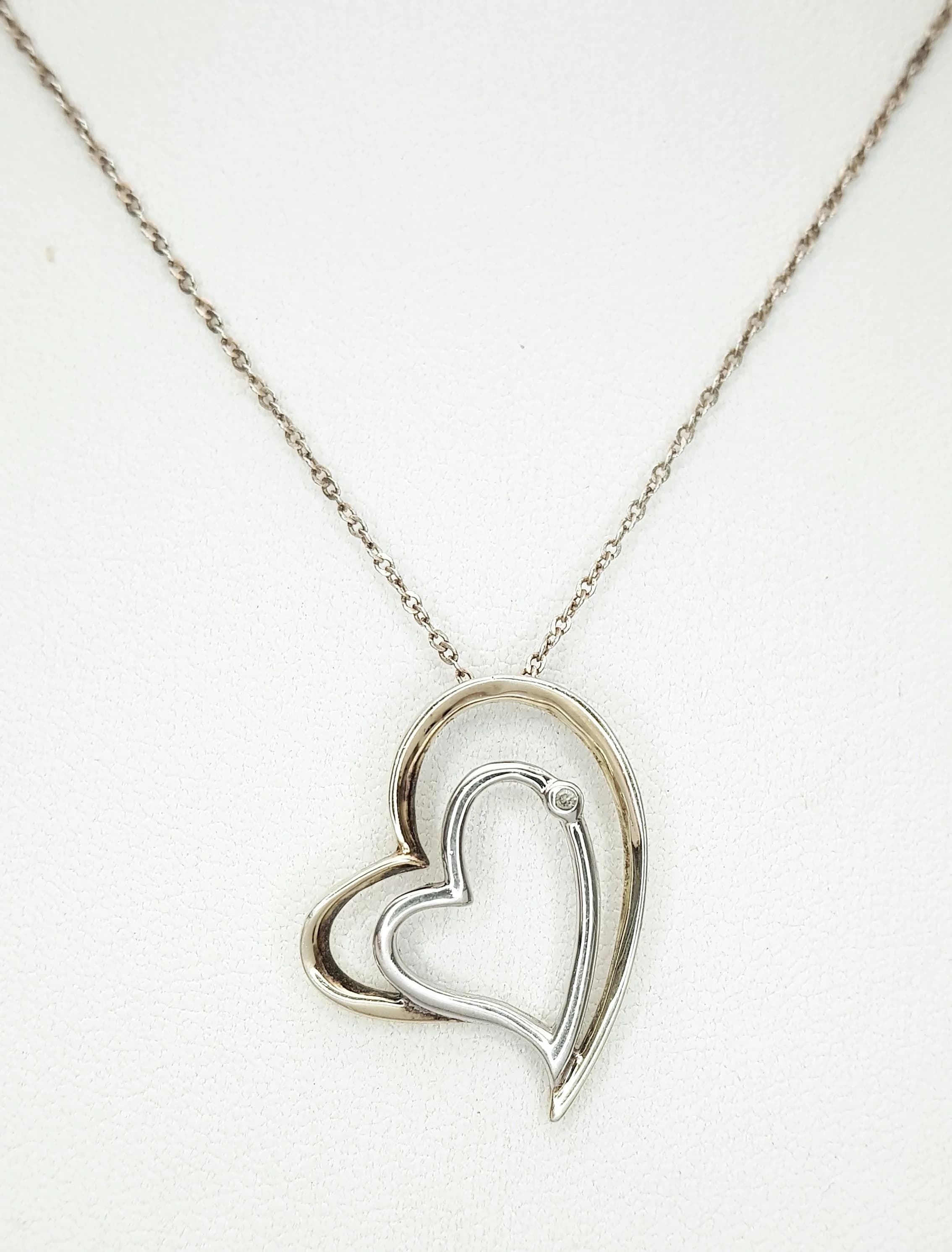 A Lovely 925 Sterling Silver Double Heart Pendant Necklace - 44cm Length. Features an openwork double heart pendant with a small white stone detail on a fine silver chain. The pendant measures 2.5cm x 2cm. Gross weight 2.88 grams.