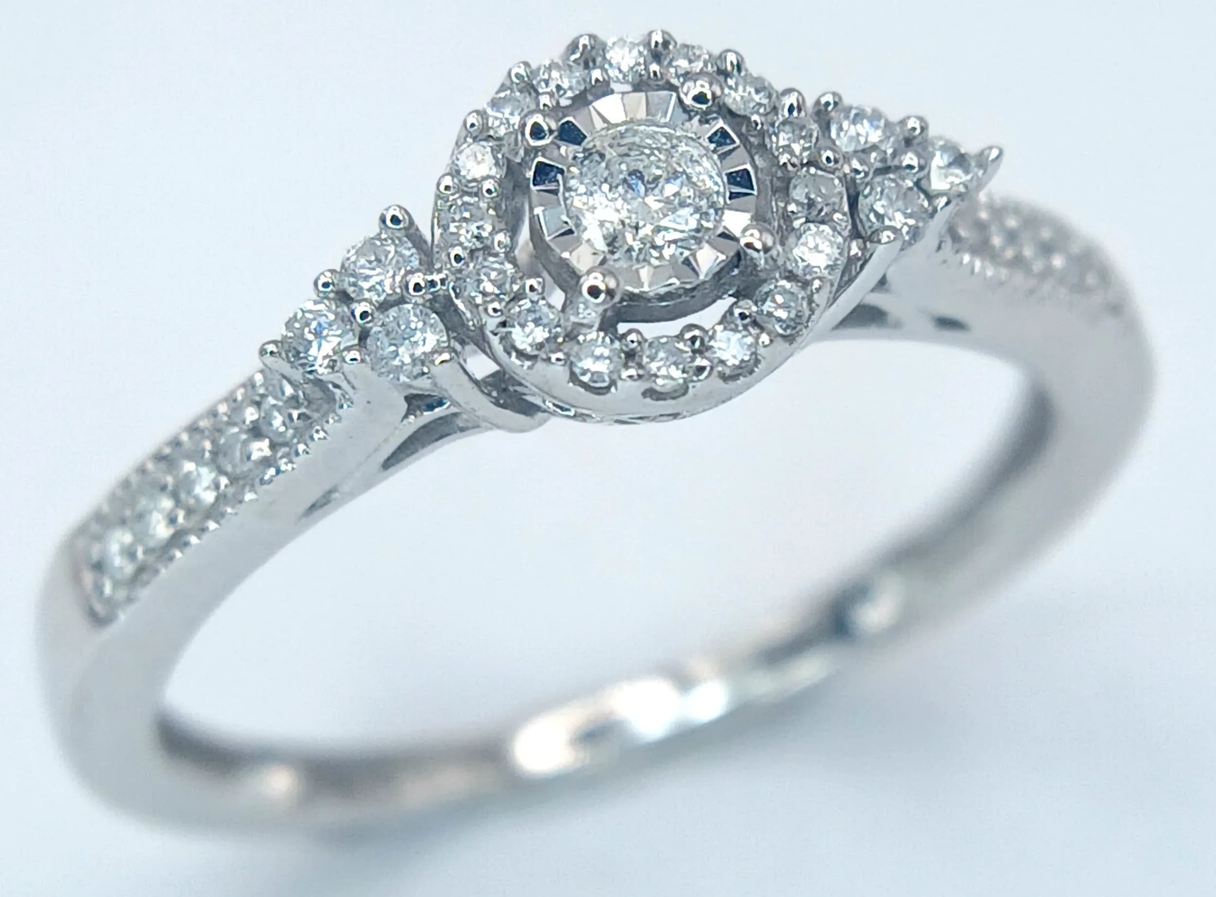 A 9K WHITE GOLD, DIAMOND SET, HALO DESIGN RING. 0.15CTW. 2G, SIZE N. SC 5027