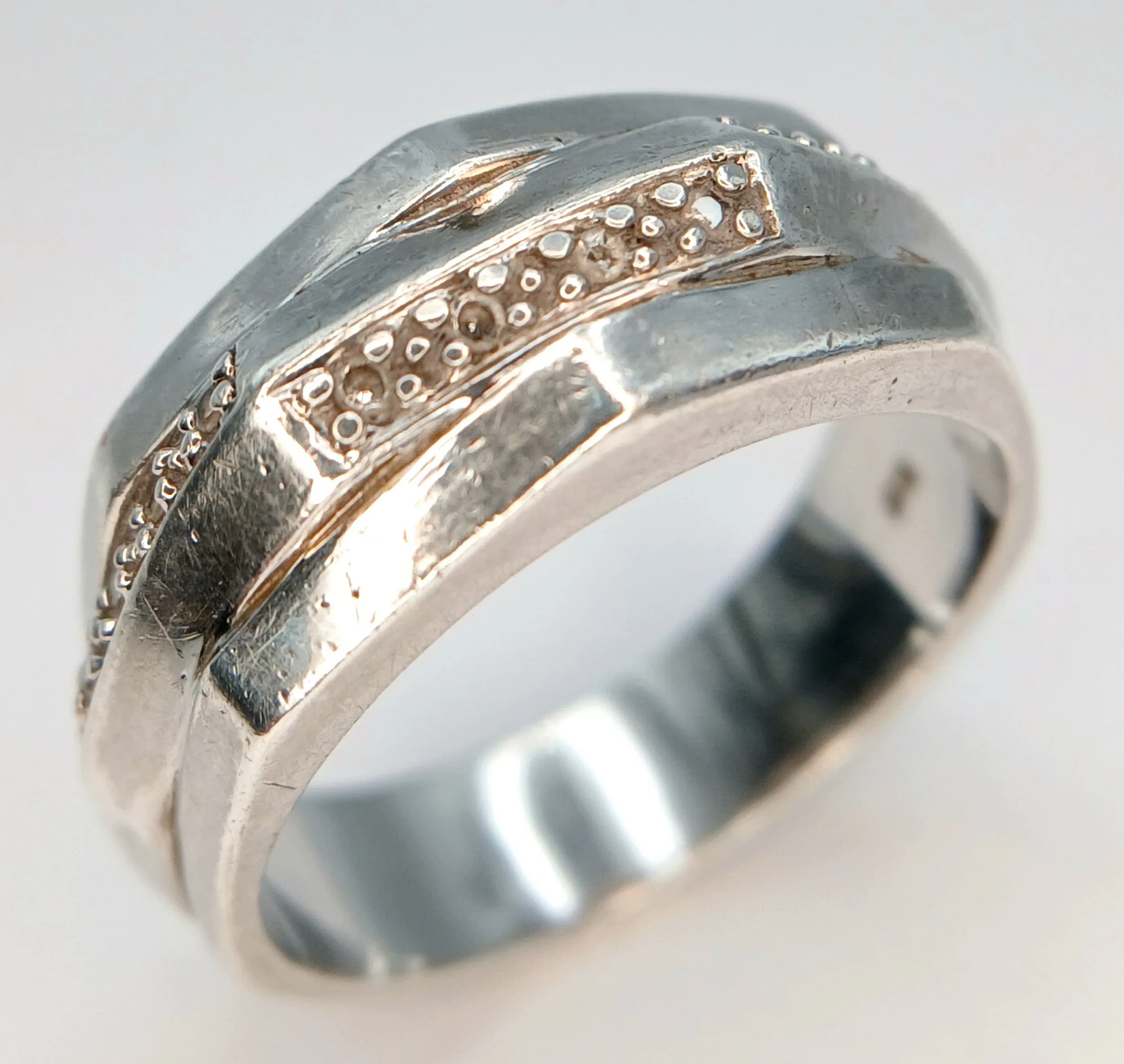 A Stylish 925 Sterling Silver Cubic Zirconia Set Multi-Row Band Ring Size M. The Ring features a wide layered design with Round Cut Cubic Zirconia Stones set across the centre. Gross weight 4.57 grams.