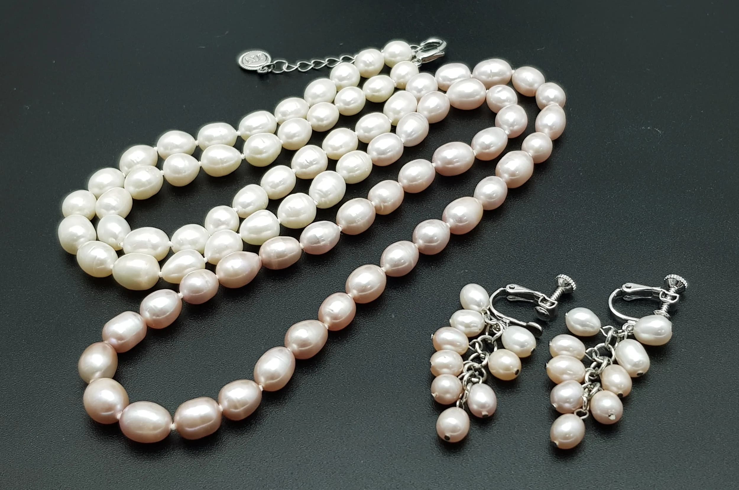 A stunning matching set of Freshwater Pearl necklace ( length 80cm) and earrings. Matinee lenth strand of large oval pearl necklace with individual knotted pearls, and pearl cluster set drop earrings. Pearl-8mm approx.