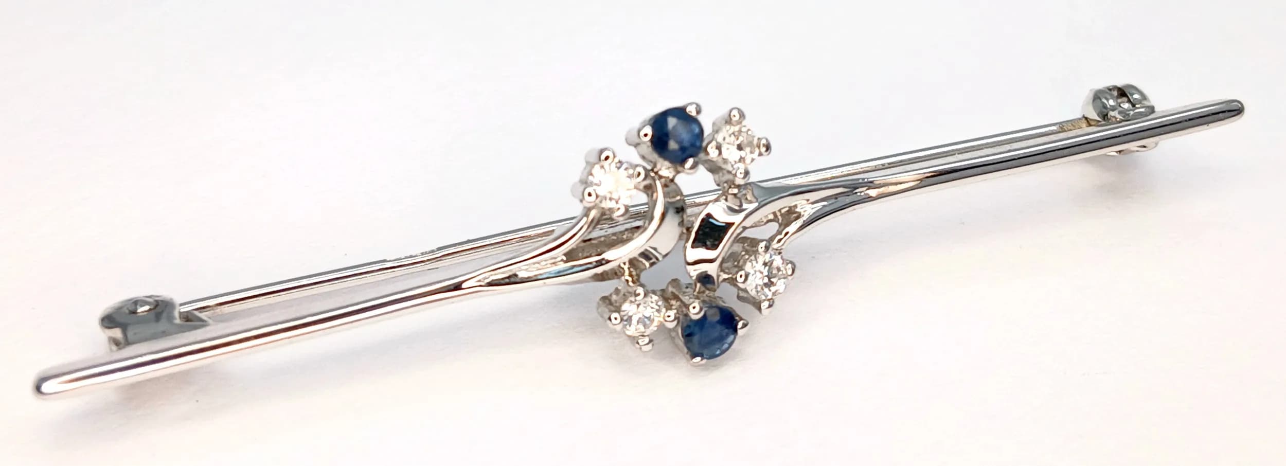 A 925 Sterling Silver Bar Brooch with Blue and Clear Stone Floral Detail. Approx 5cm length. 2.27g.