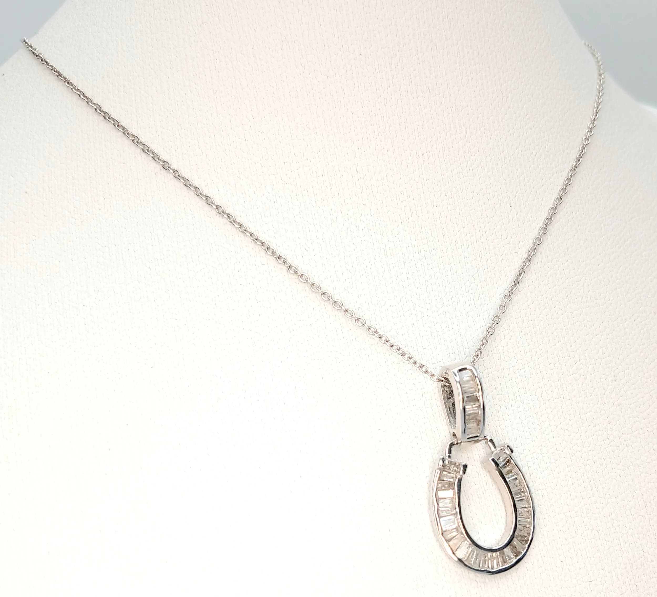 A 925 Silver Clear Stone Set Horseshoe Pendant Necklace. Both Necklace and Pendant are Hallmarked 925. Total weight 2.58g. Approx 45cm chain length with a 1cm pendant drop.