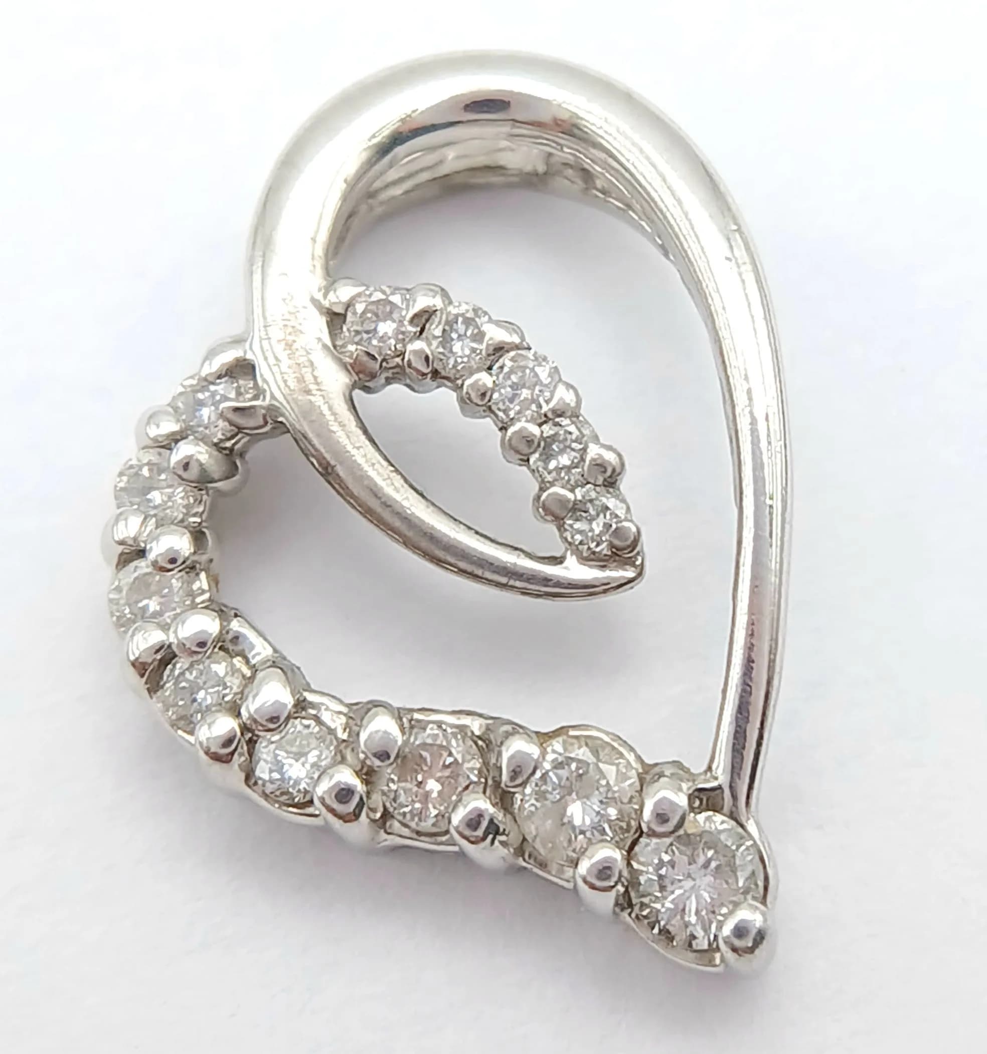 A 9K WHITE GOLD, DIAMOND SET, OPEN HEART PENDANT. ENGRAVED ON THE BACK "LOVE US A JOURNEY". 0.20CTW. 1.3G. SC 5047