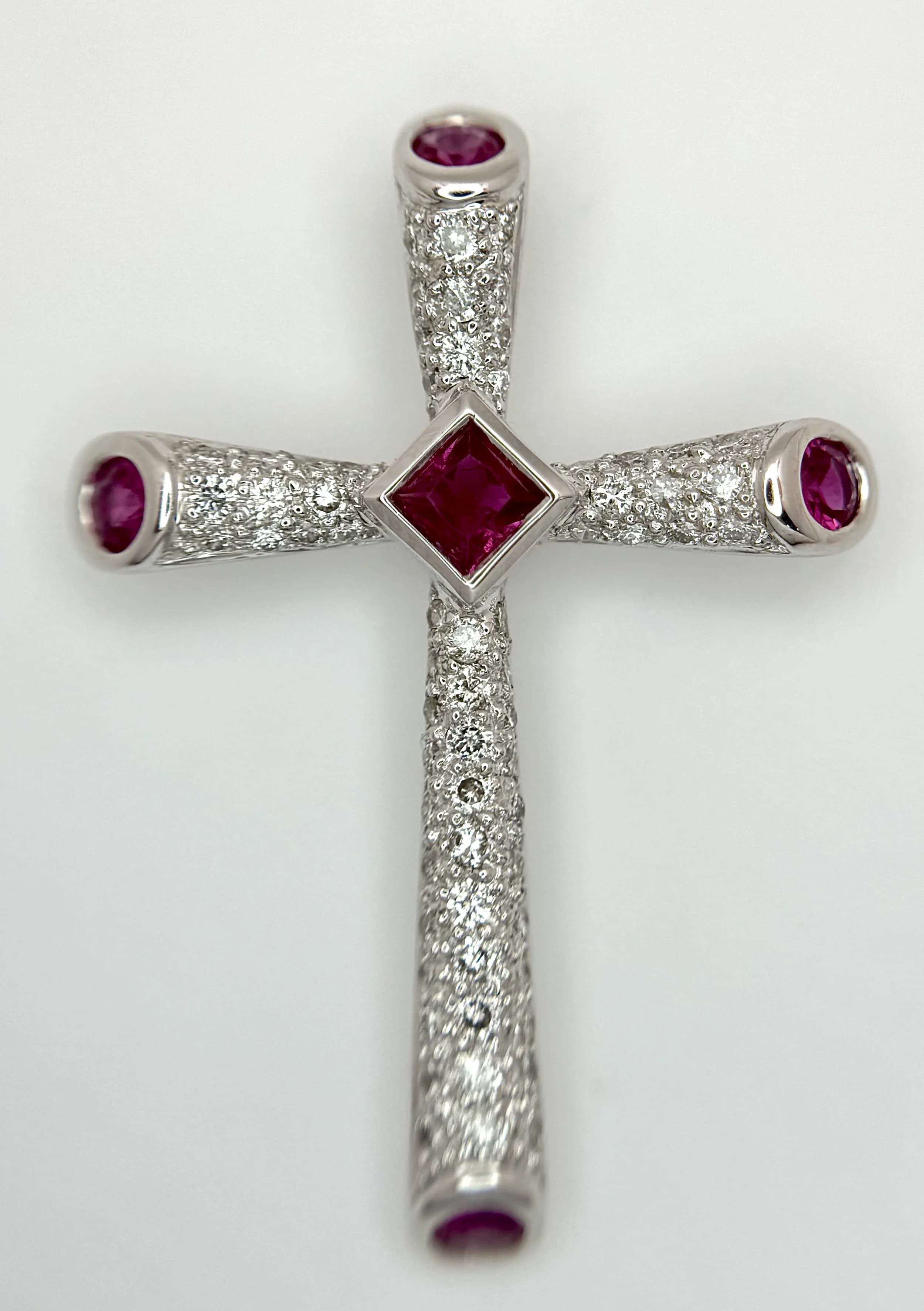 An 18K White Gold Ruby and Diamond Cross Pendant. Circa 0.45ctw diamonds. 3.4cm x 2.4cm. 3.6g total weight. Ref: 22/63205