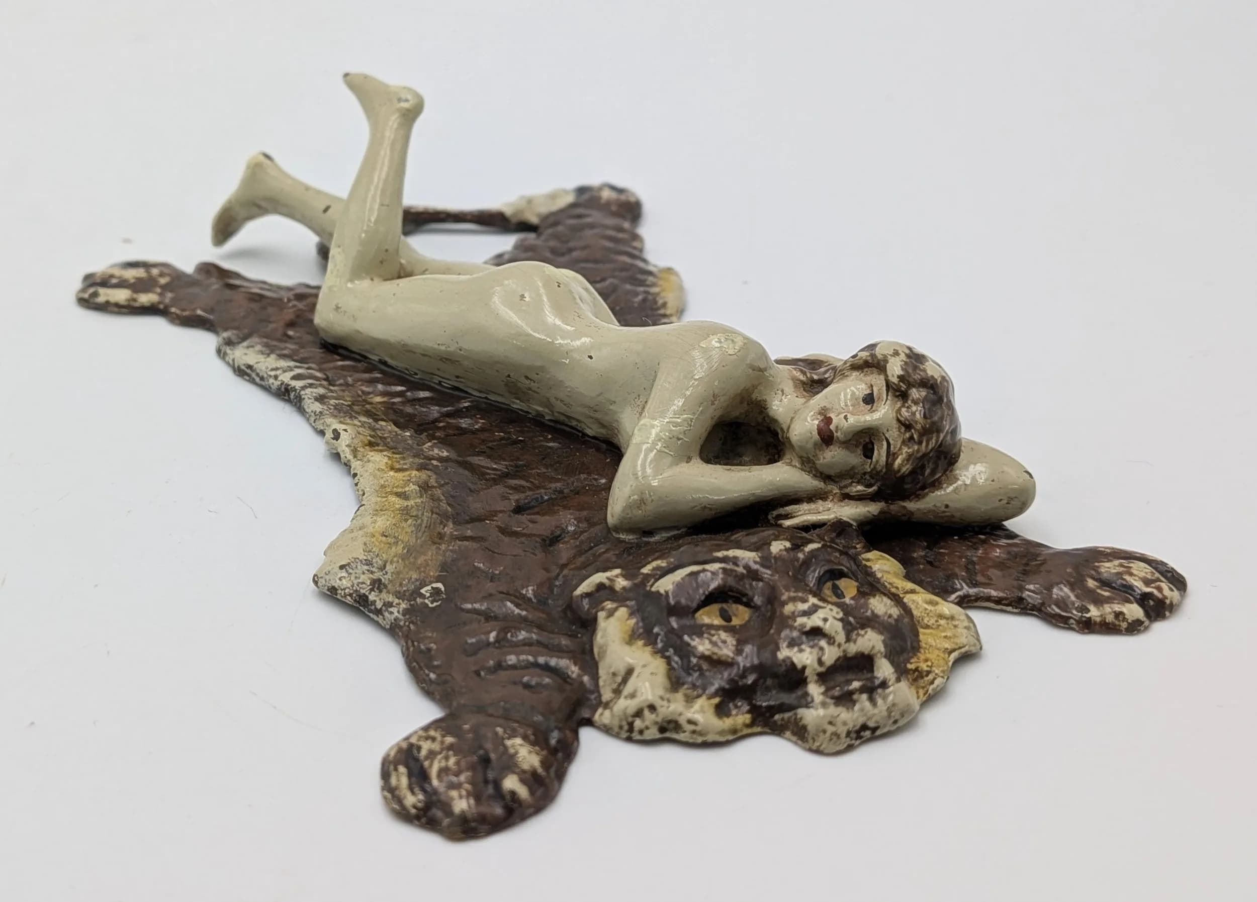 A Cold Painted Bronze by Franz Bergman (Austrian, 1861-1936). A nude woman laying on a tiger skin rug. 12cm length x 3cm height x 7.5cm width.