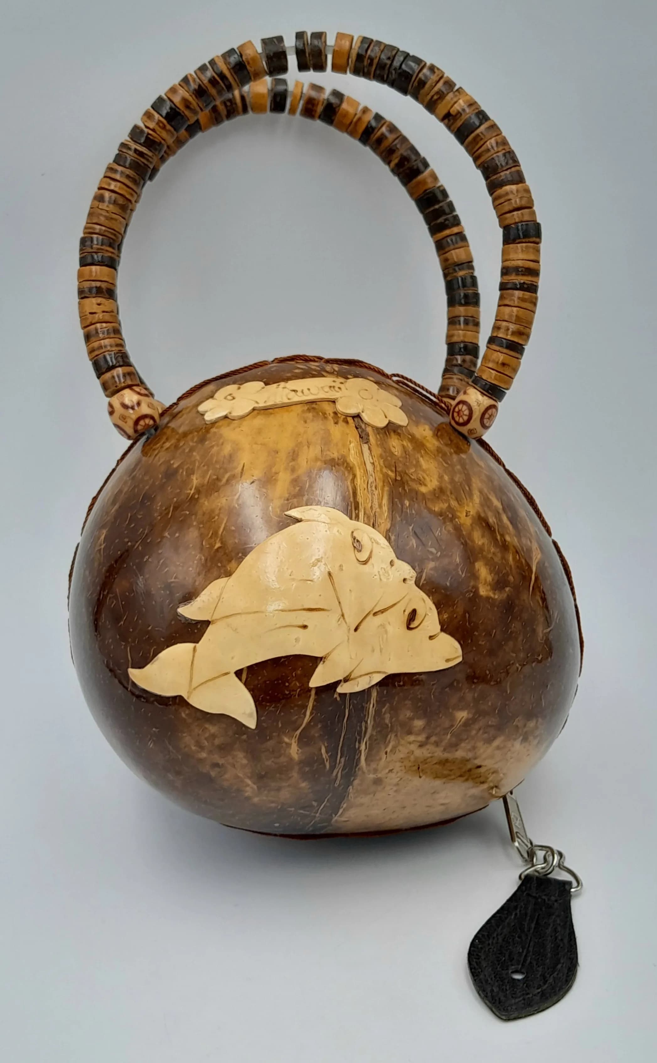 A Vintage Hawaiian Souvenir Purse Made From Treated Coconut Shell - Features a carved dolphin design and beaded handles. 15 x 22cm.