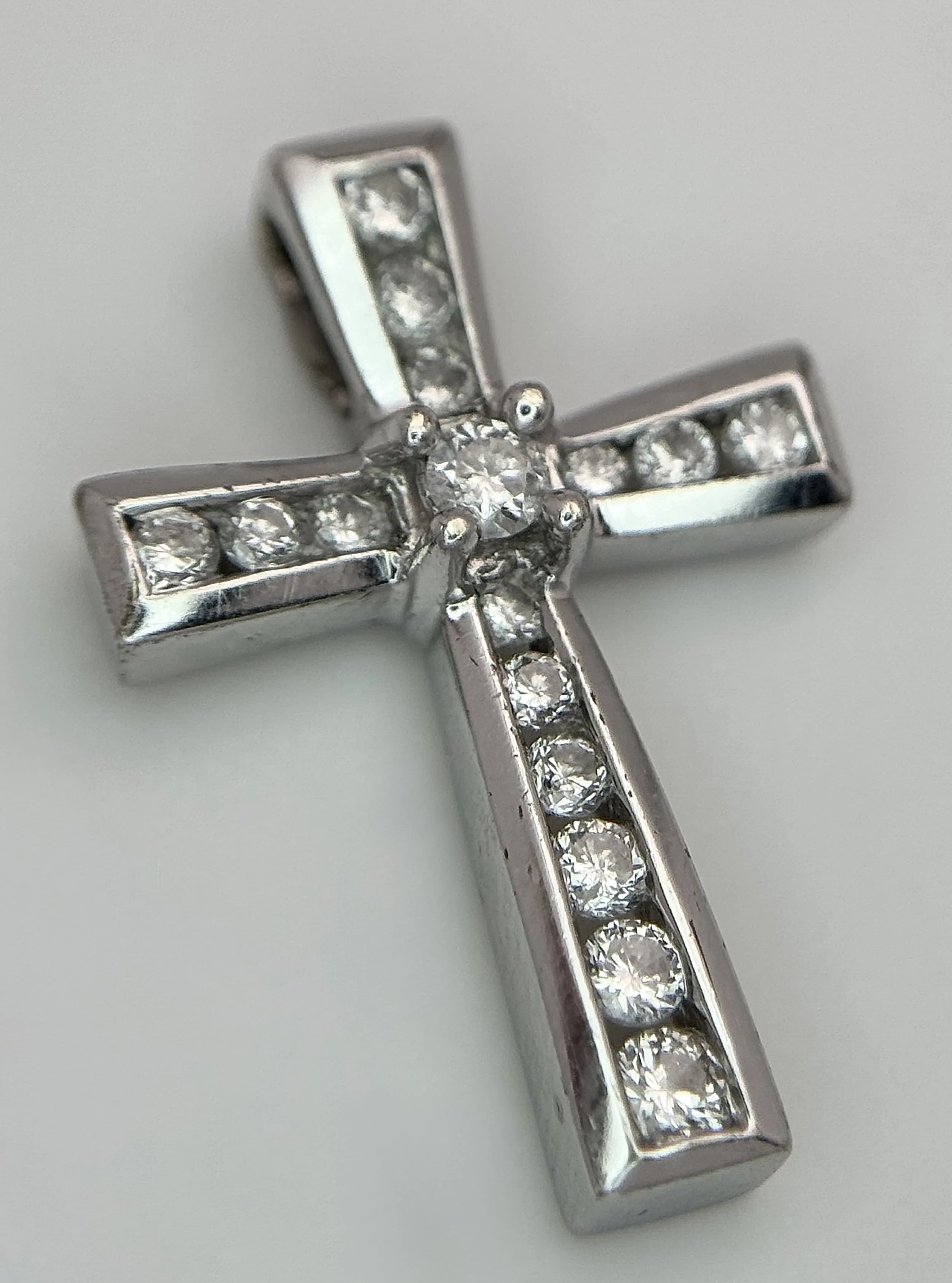 A 9K WHITE GOLD, DIAMOND SET CROSS PENDANT. 1.3G. SC 5018