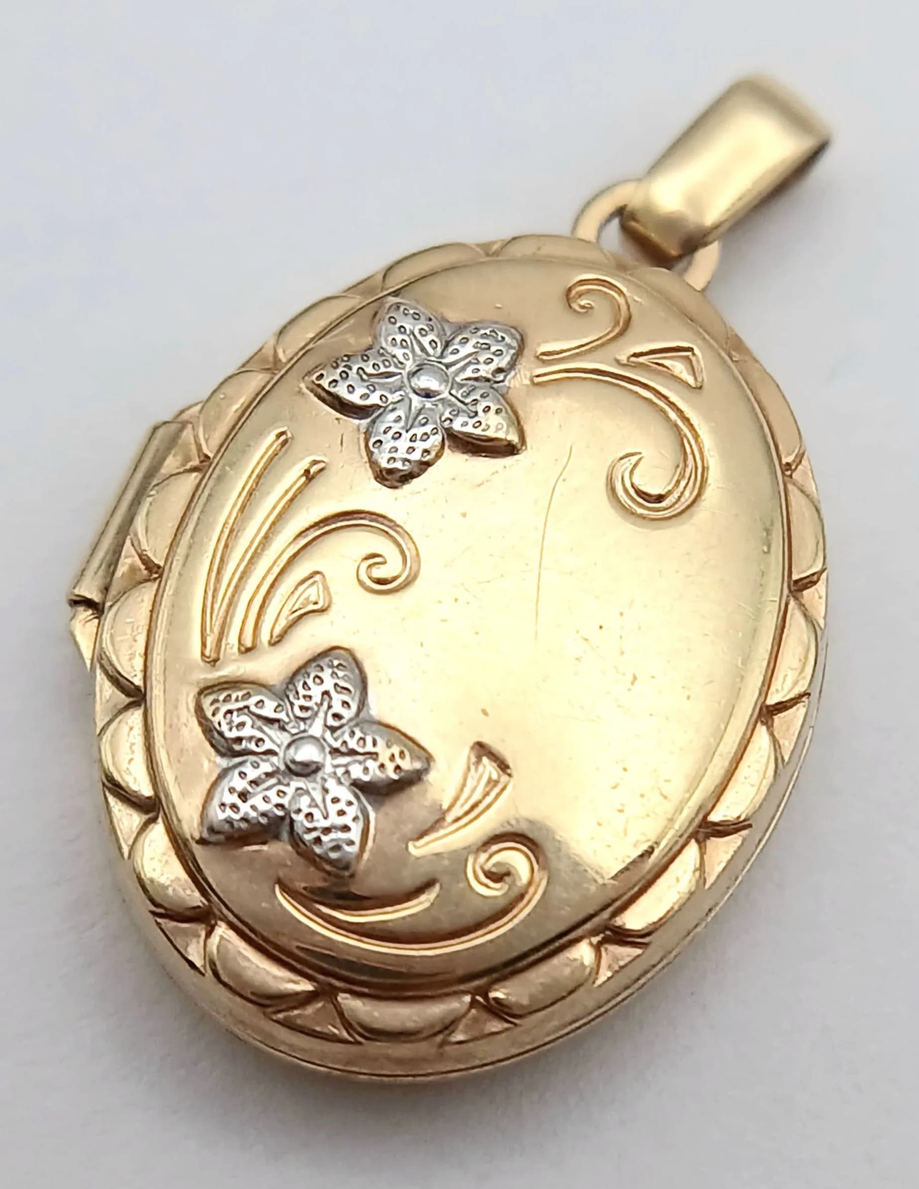 A 9K YELLOW GOLD, FLOWER DESIGN, OVAL LOCKET PENDANT. 1.2G. SC 5024