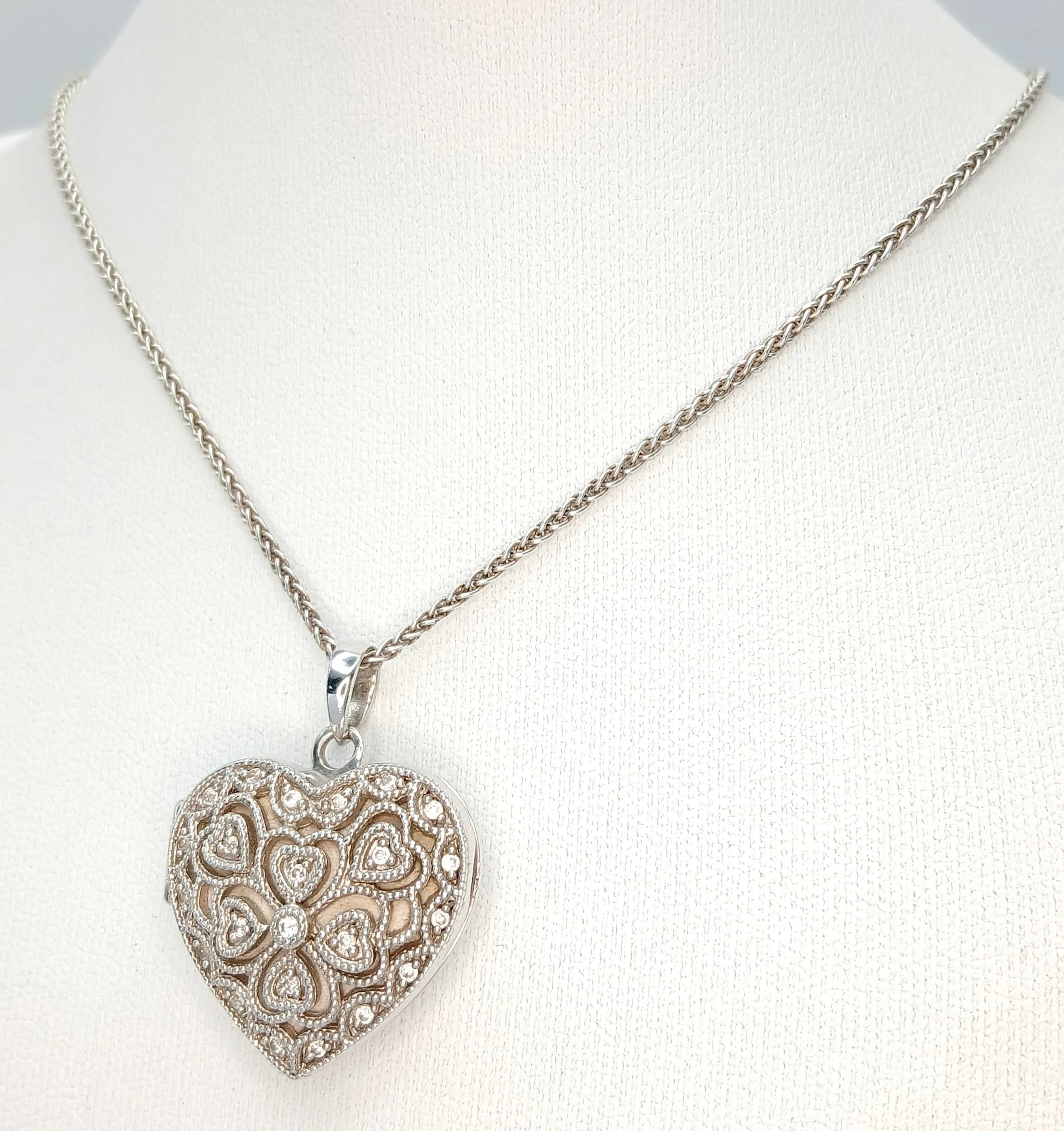 A Charming Italian 925 Sterling Silver Cubic Zirconia Set Heart Locket Pendant Necklace-46cm Length Chain. The Openwork Heart Locket is set with Round Cut Cubic Zirconia Stones and measures 2cm x 2cm. The Locket opens to reveal an inner compartment. The Necklace has a gross weight of 11.77 grams.