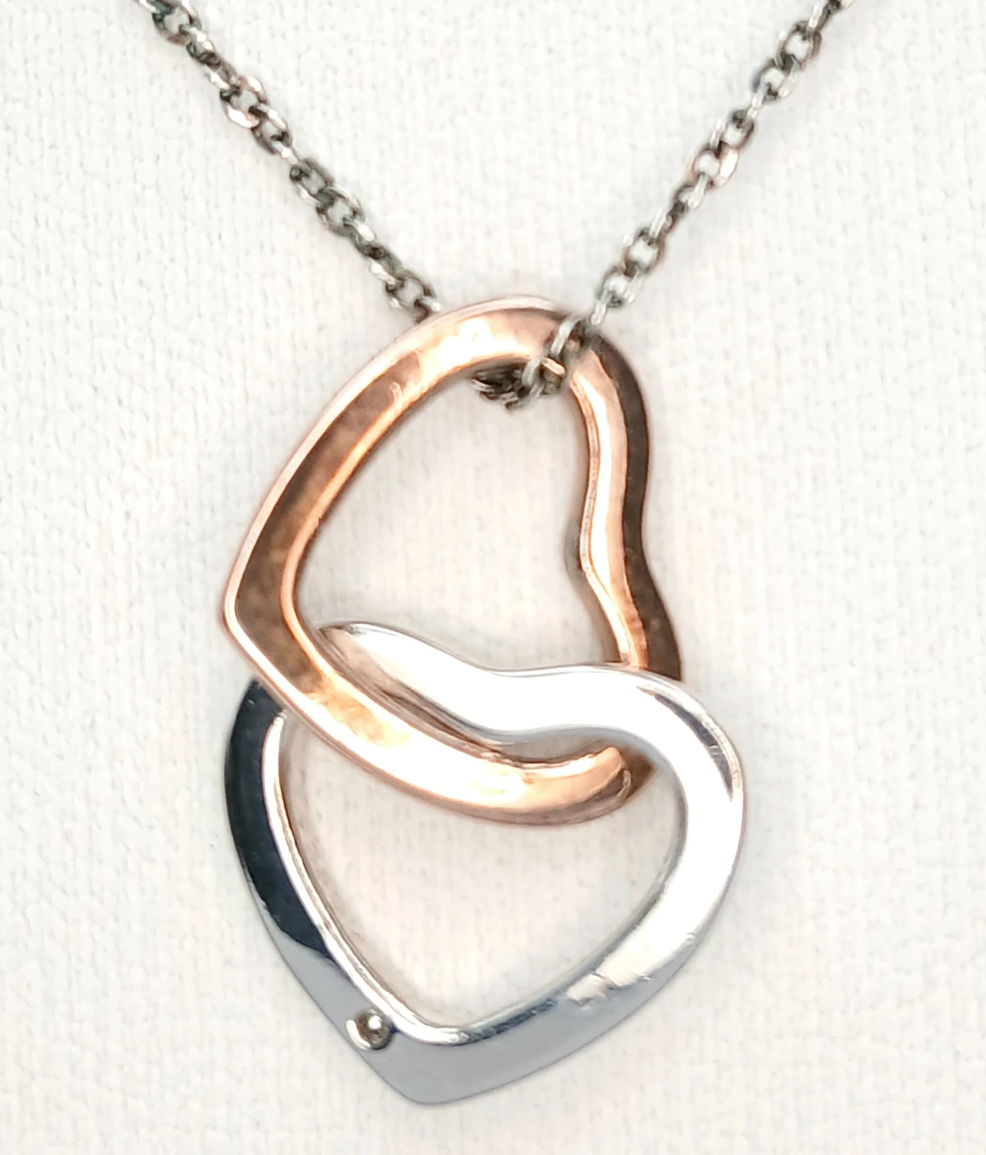 A Pretty 925 Sterling Silver Heart Pendant Necklace. The pendant features an open heart-shaped decorative silver design. The necklace measures 44cm length. The pendant measures 1.5cm x 1.5cm. Gross weight of necklace is 3.52 grams.