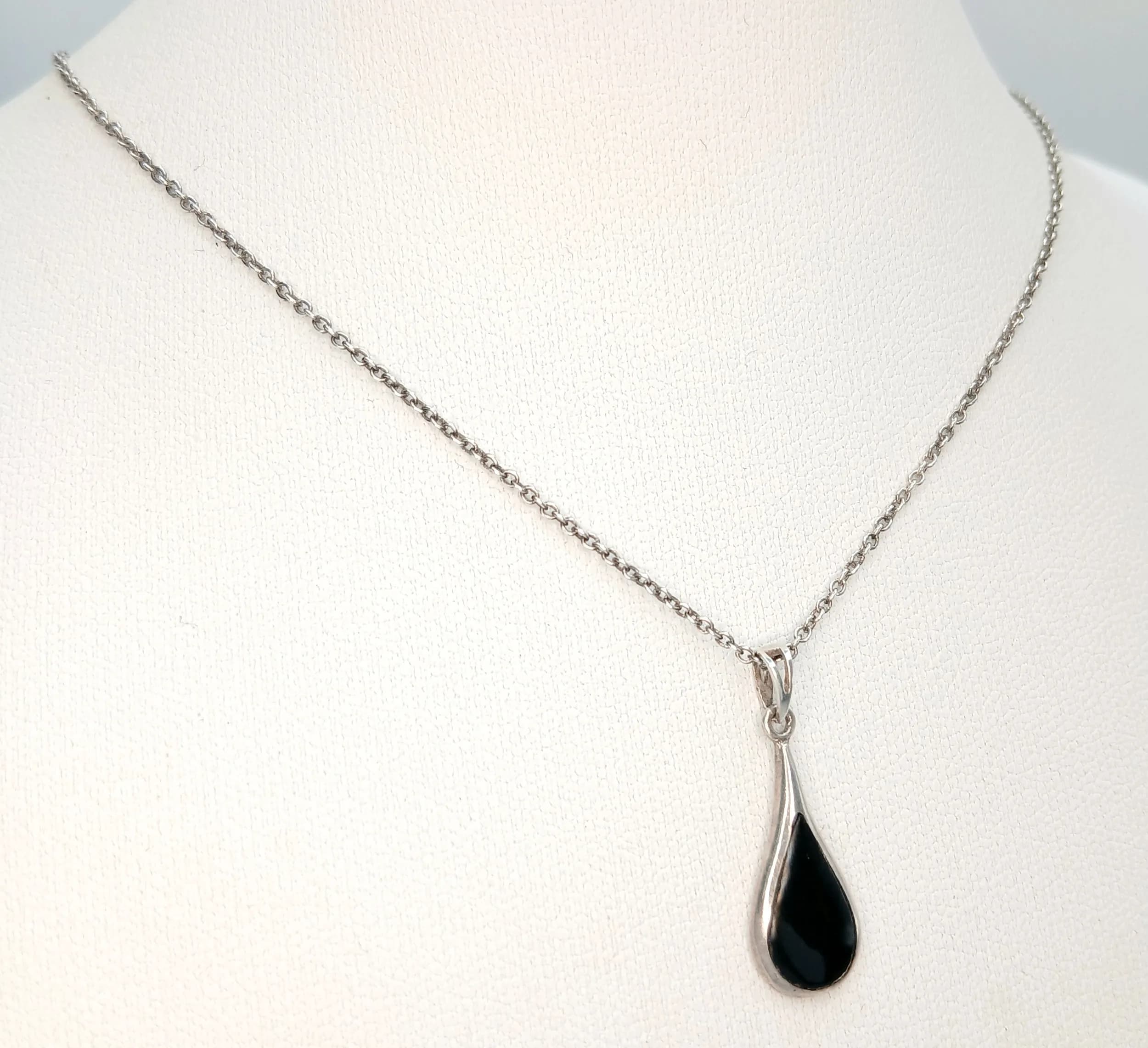 A Lovely 925 Sterling Silver Black Onyx Set Pendant Necklace. The necklace is set with a pear-shaped black onyx pendant drop. The necklace measures 40cm length. The pendant measures 2cm drop. The necklace has a gross weight of 2.21 grams.