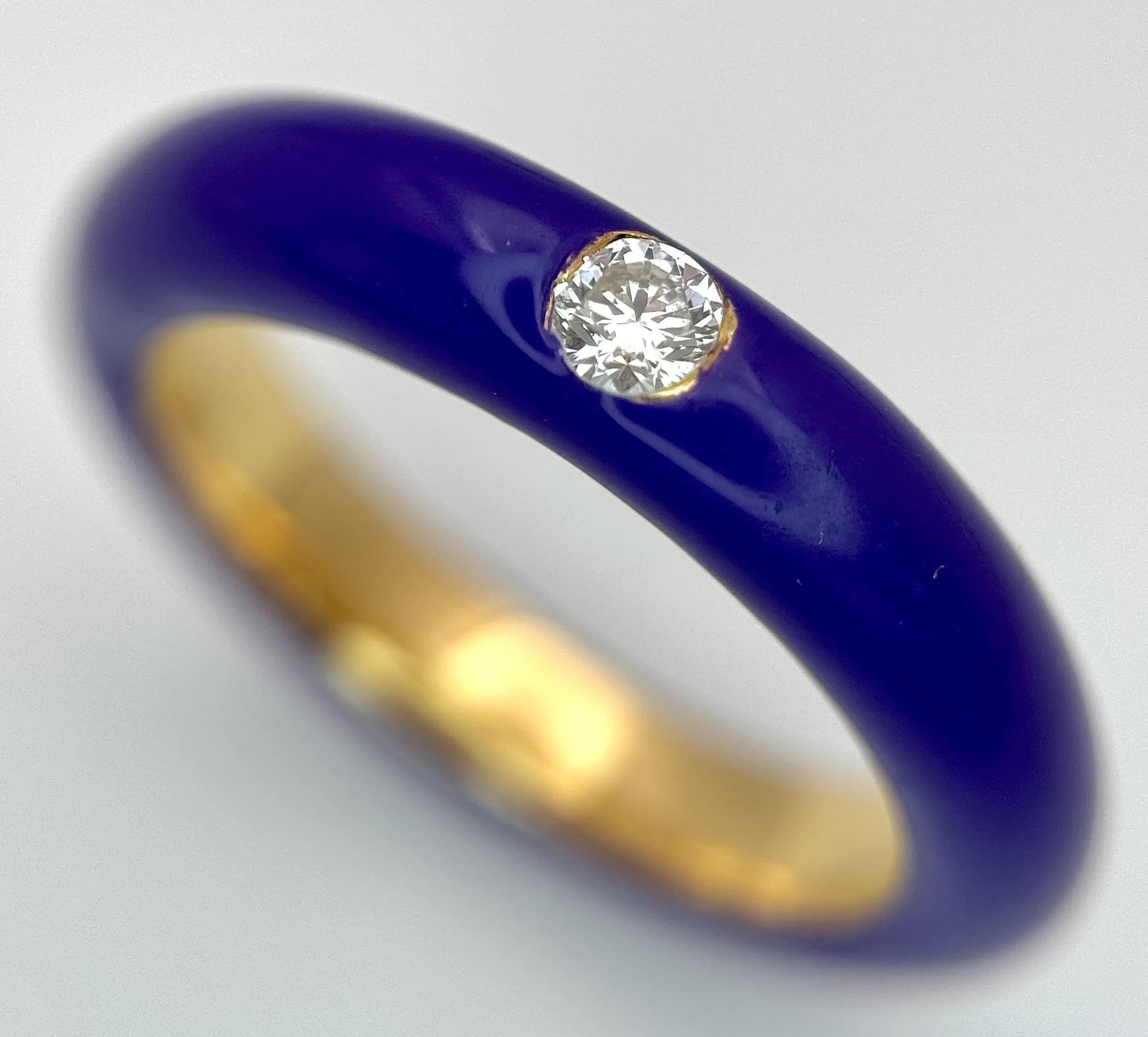 An 18K Gold, Purple Enamel and Diamond Band Ring. 0.15ct round brilliant deep set diamond amongst a wonderful purple finish. Size N. 8.6g total weight. MT20.