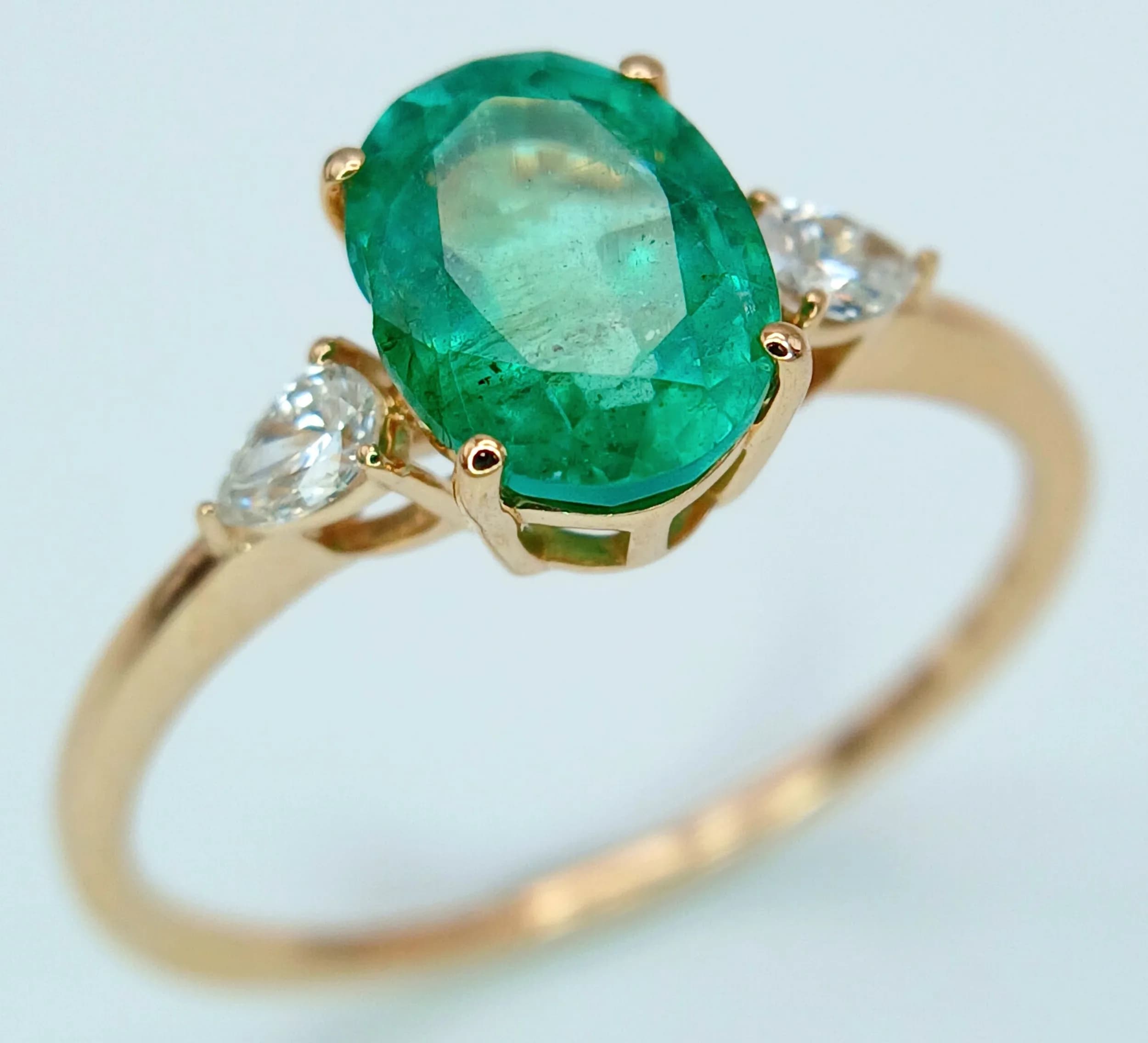 A VERY PRETTY 14K GOLD RING WITH OVAL EMERALD (1.33cwt) FLANKED BY .14cwt OF DIAMONDS AND COMING WITH THE H.R.D.ANTWERP CERTIFICATE . 1.58gms size N/O CLR13393