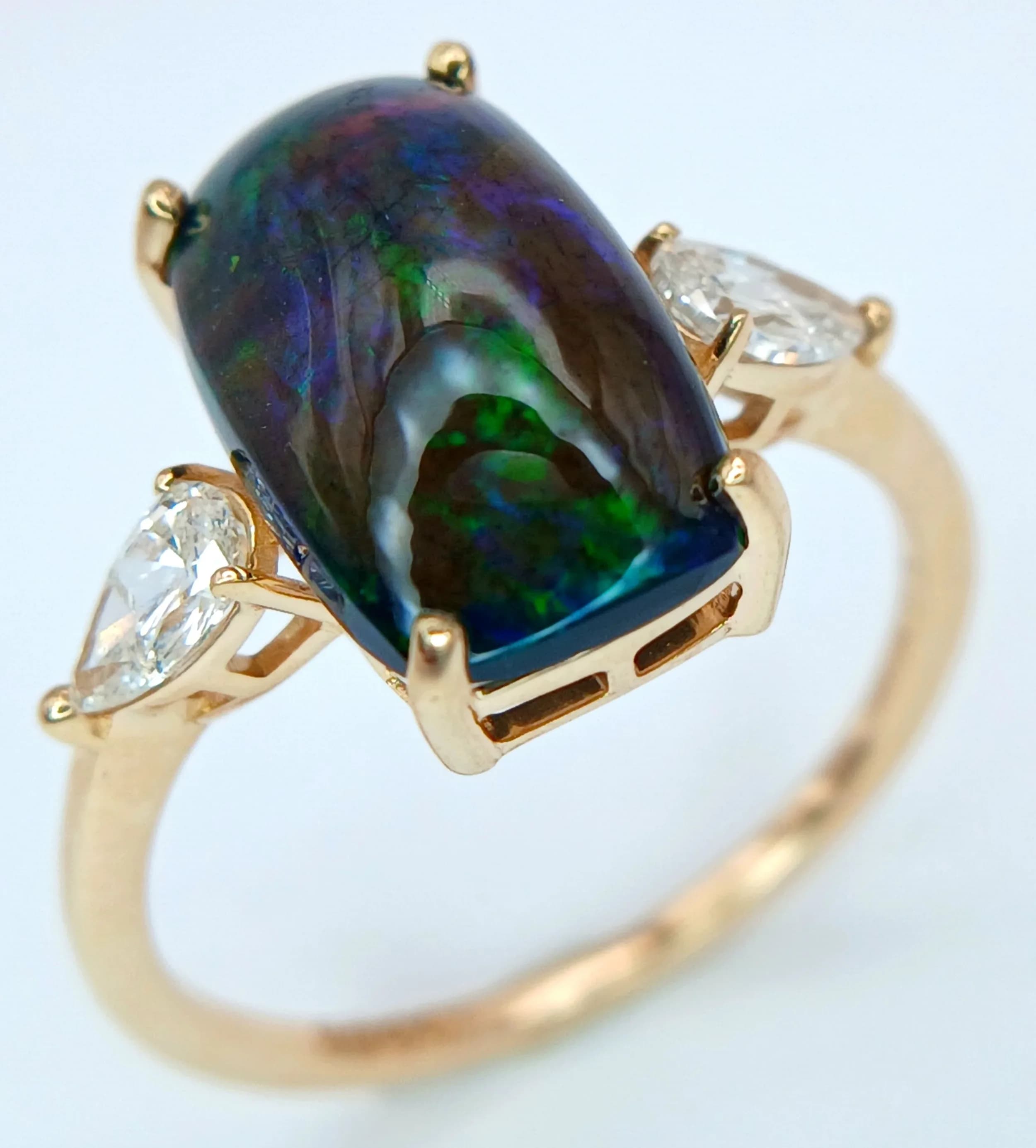 A STUNNING RING with 2.8cwt CUSHION CUT BLACK OPAL STONE FLANKED BY 2 DIAMONDS .42cwt AND SET IN 14K GOLD . 2.28gms size N COMING WITH THE H.R.D. ANTWERP CERTIFICATE. CLR13358