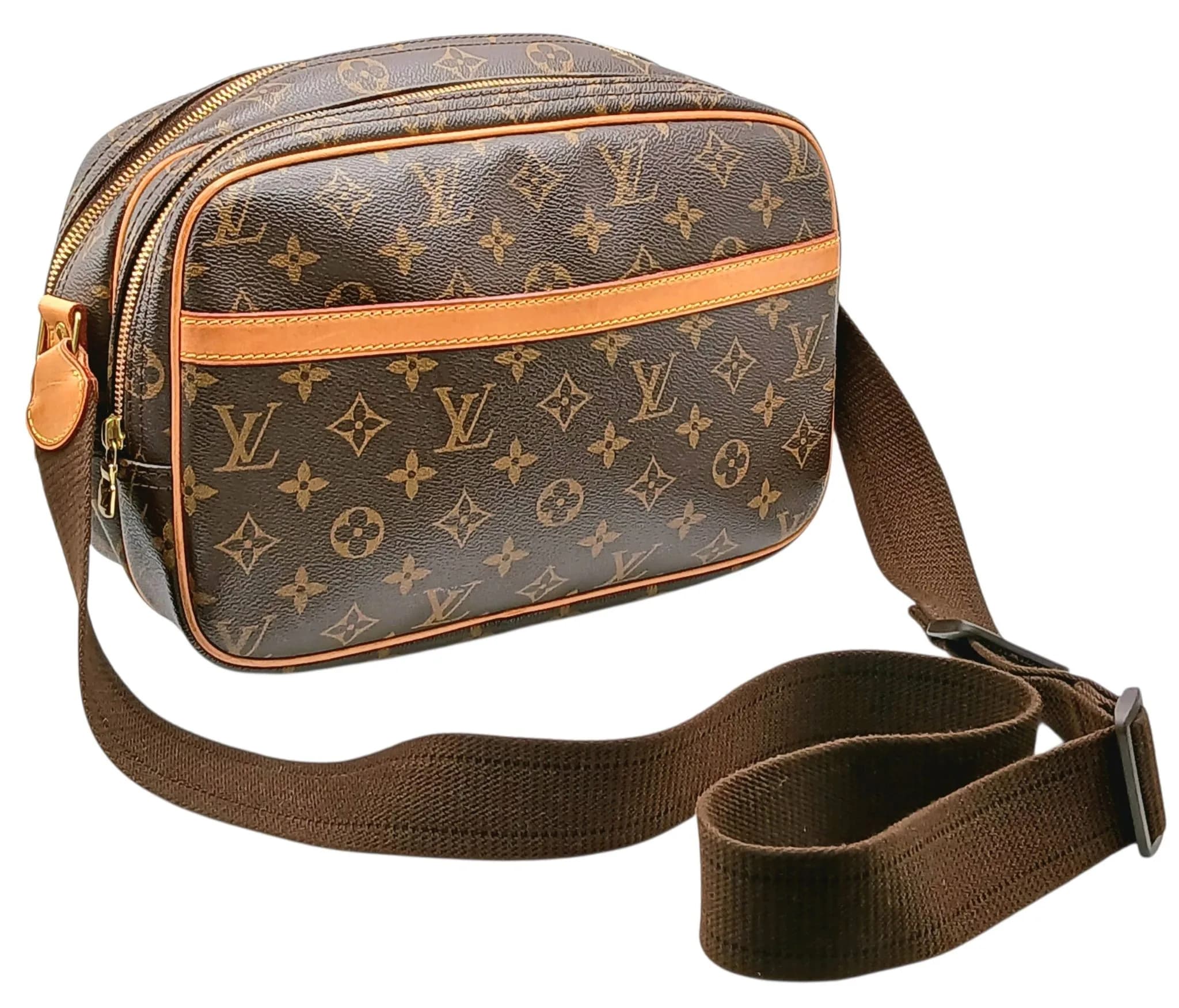 A Brown Louis Vuitton Monogram Canvas Reporter PM Shoulder Bag. Brown Monogram coated canvas exterior with adjustable canvas shoulder strap, dual zip-top compartments, front slip pocket and gold-tone hardware. Beige canvas interior with two compartments and a slip pocket. Approx. 29cm length x 17cm height x 12cm depth. Comes with a certificate of authenticity and dust cover. Few marks and signs of wear to the leather but in good condition overall. Please see photos or request a condition report. Ref: 29443.