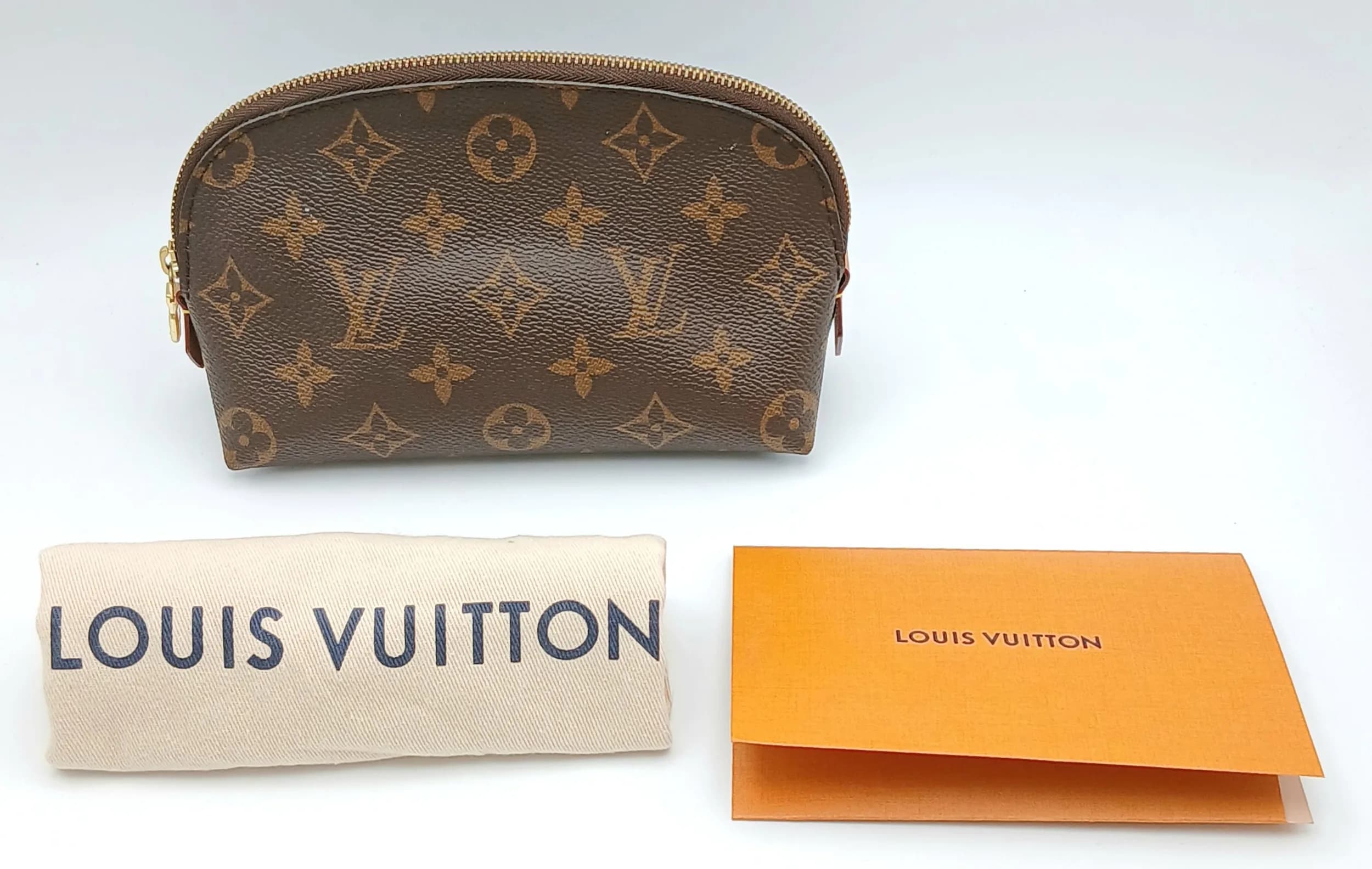 A Brown Louis Vuitton Monogram Canvas Cosmetic Pouch. Brown Monogram coated canvas exterior with gold-tone hardware and zip top closure. Beige textile interior with one main compartment and an opened pocket. Approx. 19cm length x 11cm height x 5.5cm depth. Comes with a purchased receipt and dust cover. Some marks and signs of wear of the leather. Please see photos or request a condition report. Ref: 29435.