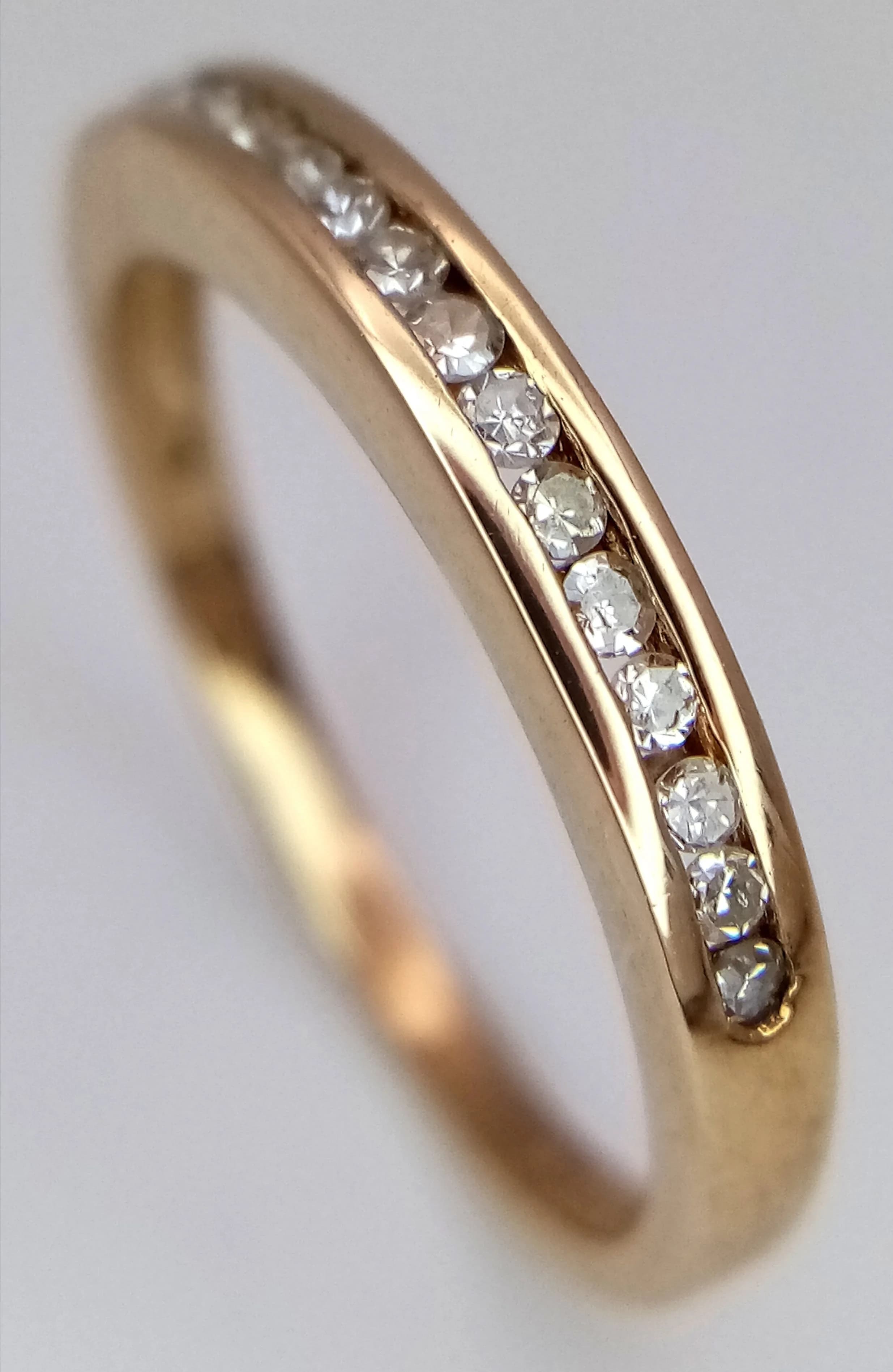 A 9K Yellow Gold, Diamond Channel Set Ring. 15 round brilliant cut diamonds - 0.15ctw. Size K 1/2. 1.7g total weight.