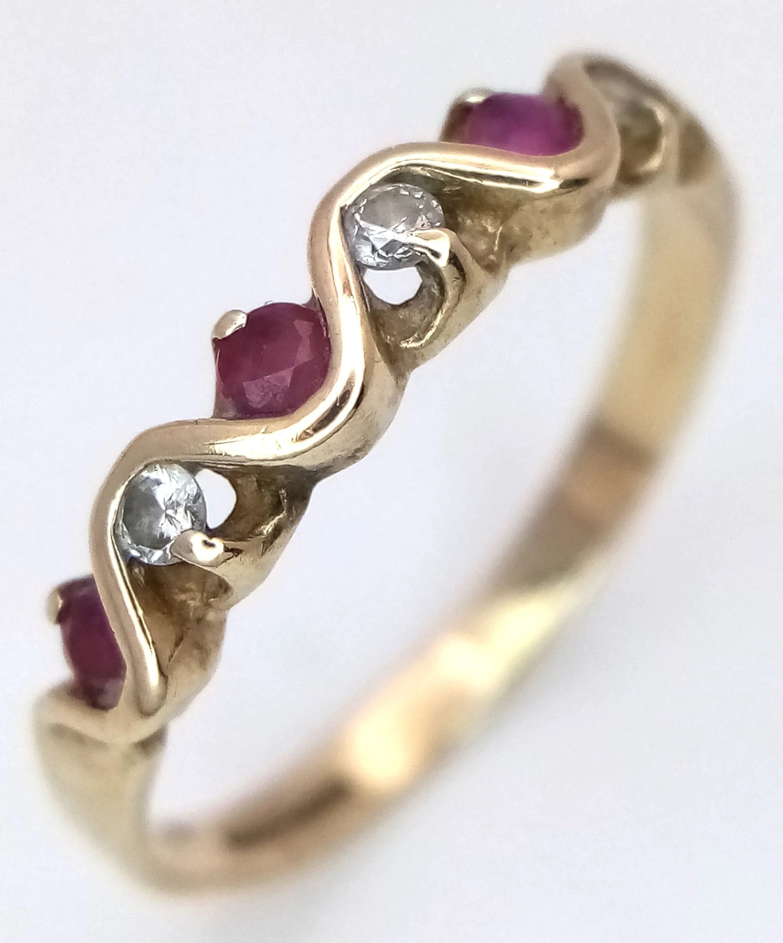A 9K yellow Gold, Diamond and Ruby Band Ring in a Wave Setting. Size L 1/2. 1.35g.