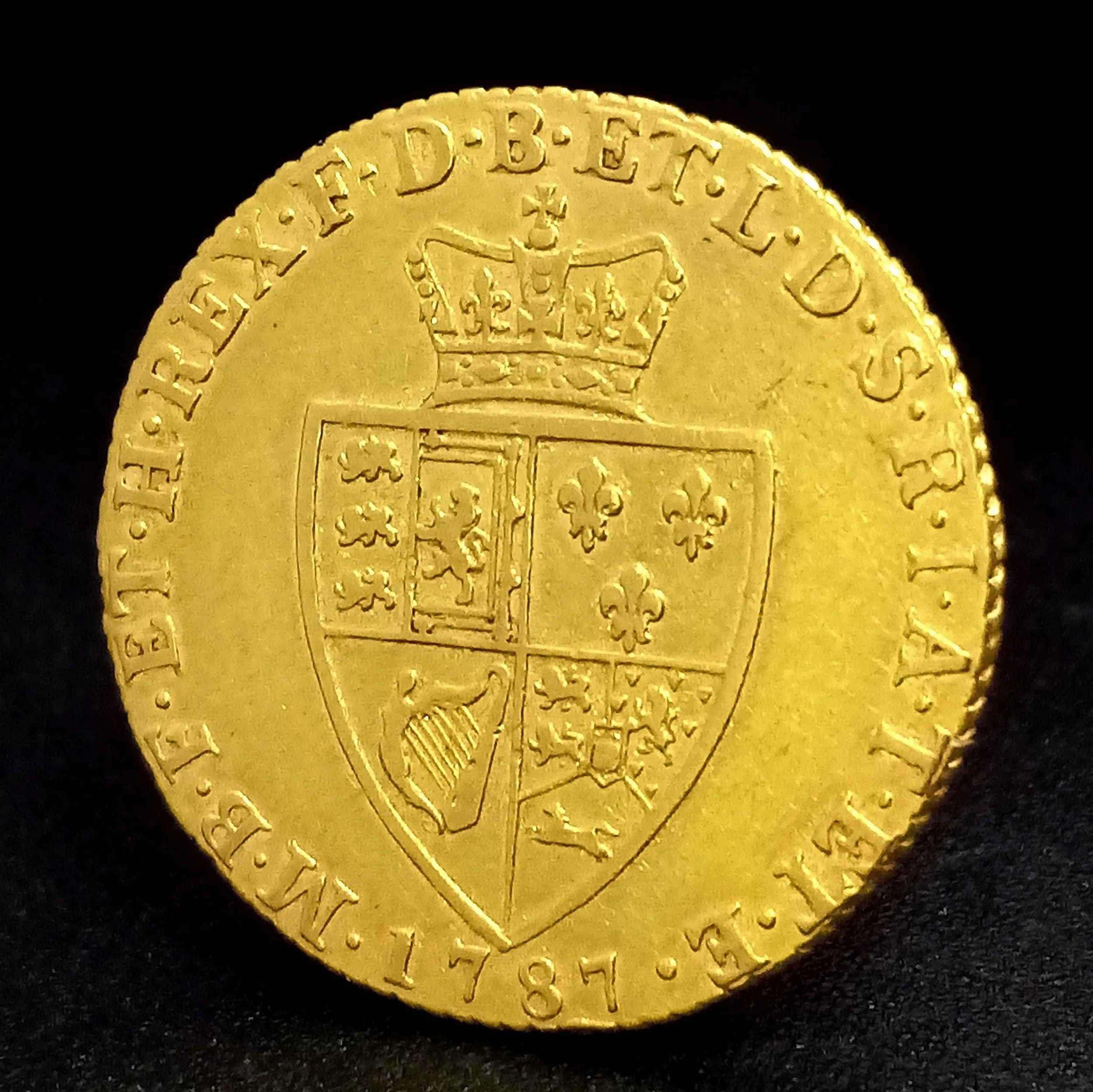 An Extremely Fine Condition 1787 George III Gold ‘Spade’ Guinea coin. Obverse: Laureate. Portrait King George III right, legend around ‘Georgivs III Dei Gratia. Reverse: Crowned and Quartered, Spade Shield of Arms and Legend. 8.4 grams.