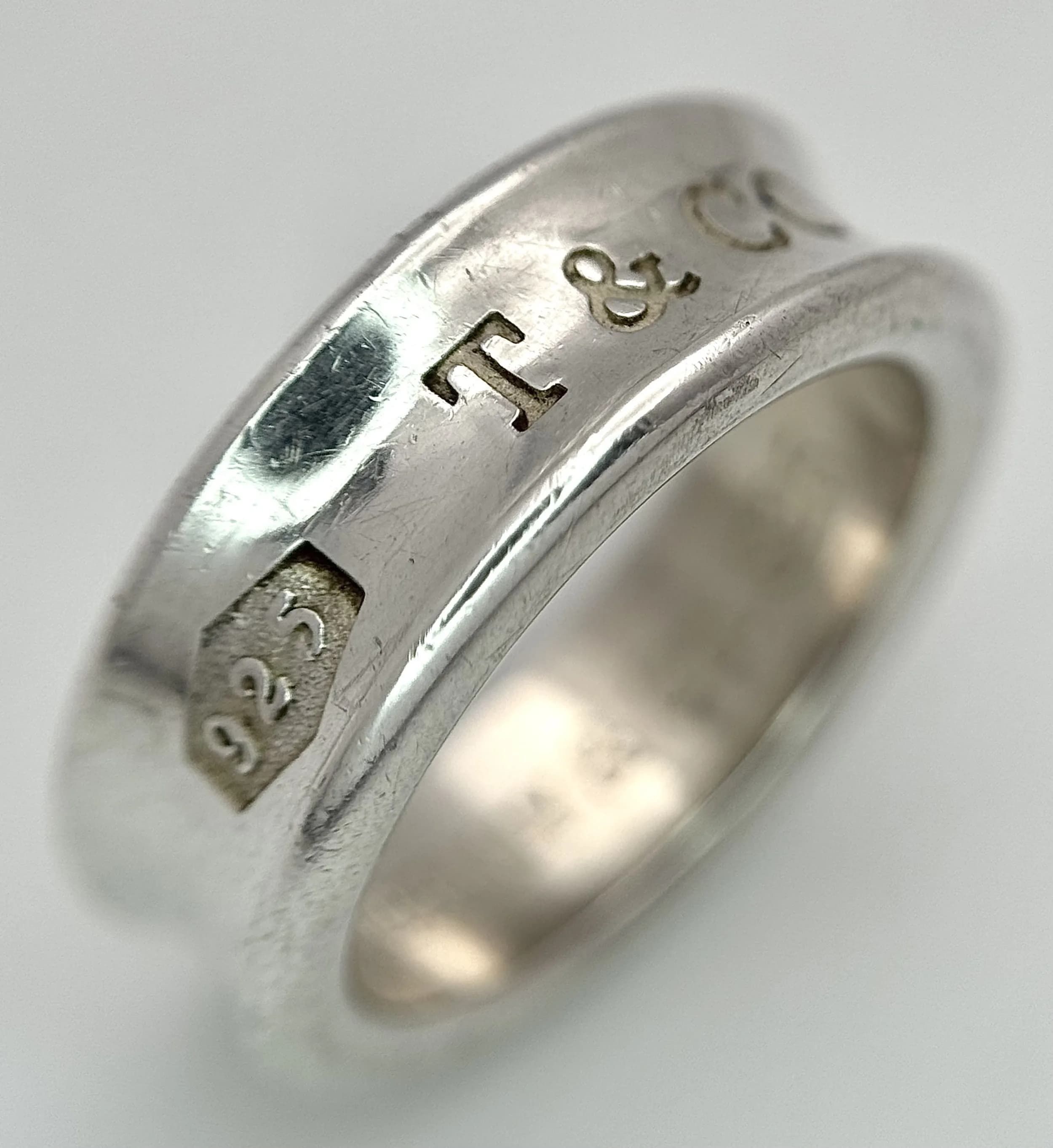 A TIFFANY AND CO, STERLING SILVER, BAND RING. 7.8G, SIZE L. A/S NN 6003