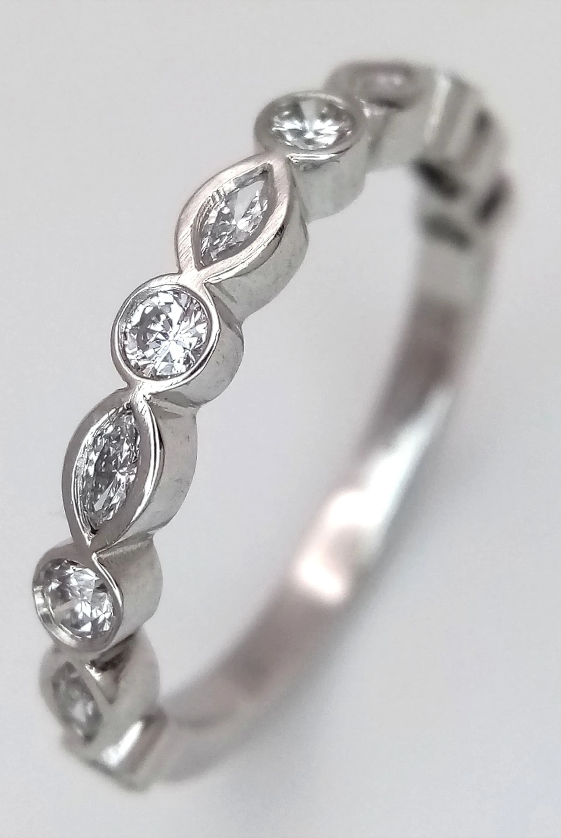 A Platinum and Alternating Diamond Shaped Half-Eternity Ring. 0.35ctw of marquise and round brilliant cut diamonds having G colour and VS2 clarity. 3.5mm width. Size J 1/2. MT03.