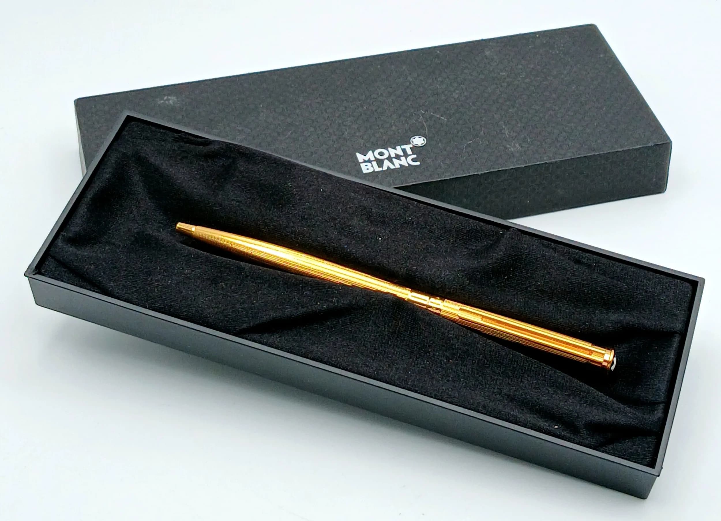 A Montblanc Gold-toned Ballpoint Pen. Gold-toned finish with ribbed barrel design. Comes with a Guarantee Certificate, care booklet and original Montblanc presentation box. Measures approx. 14cm in length. In good condition and working order. Please see photos or request a condition report. Ref: 29363.