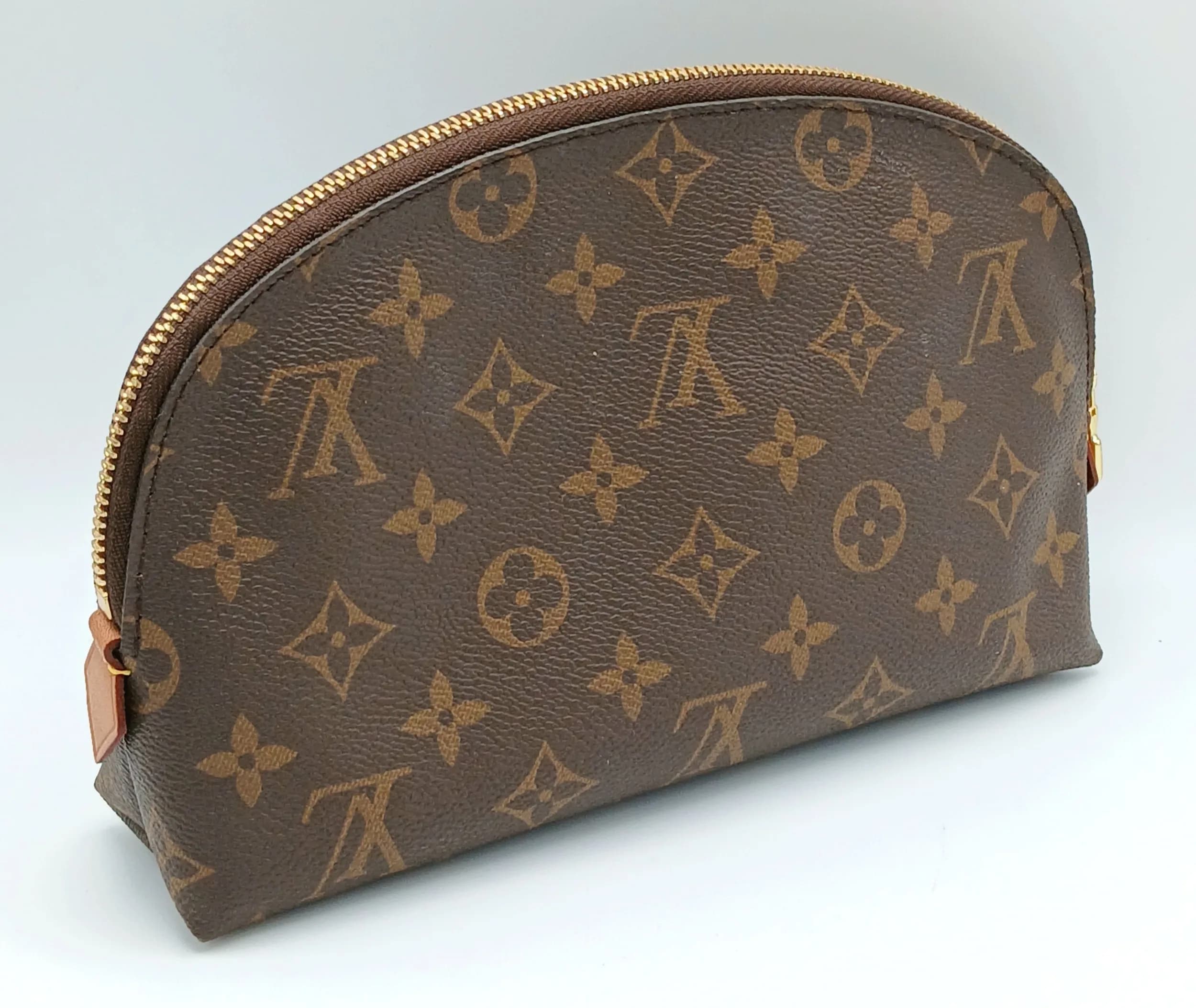 A Brown Louis Vuitton Monogram Cosmetic Pouch GM. Brown Monogram coated canvas exterior with gold-toned hardware and zipped top closure. Beige textile interior with one main compartment and two slip pockets. Approx. 24cm length x 13cm height x 5cm depth. Comes with a dust cover and purchased receipt. Some marks to the interior and some signs of light wear to the exterior. Please see photos or request a condition report. Ref: 29434.