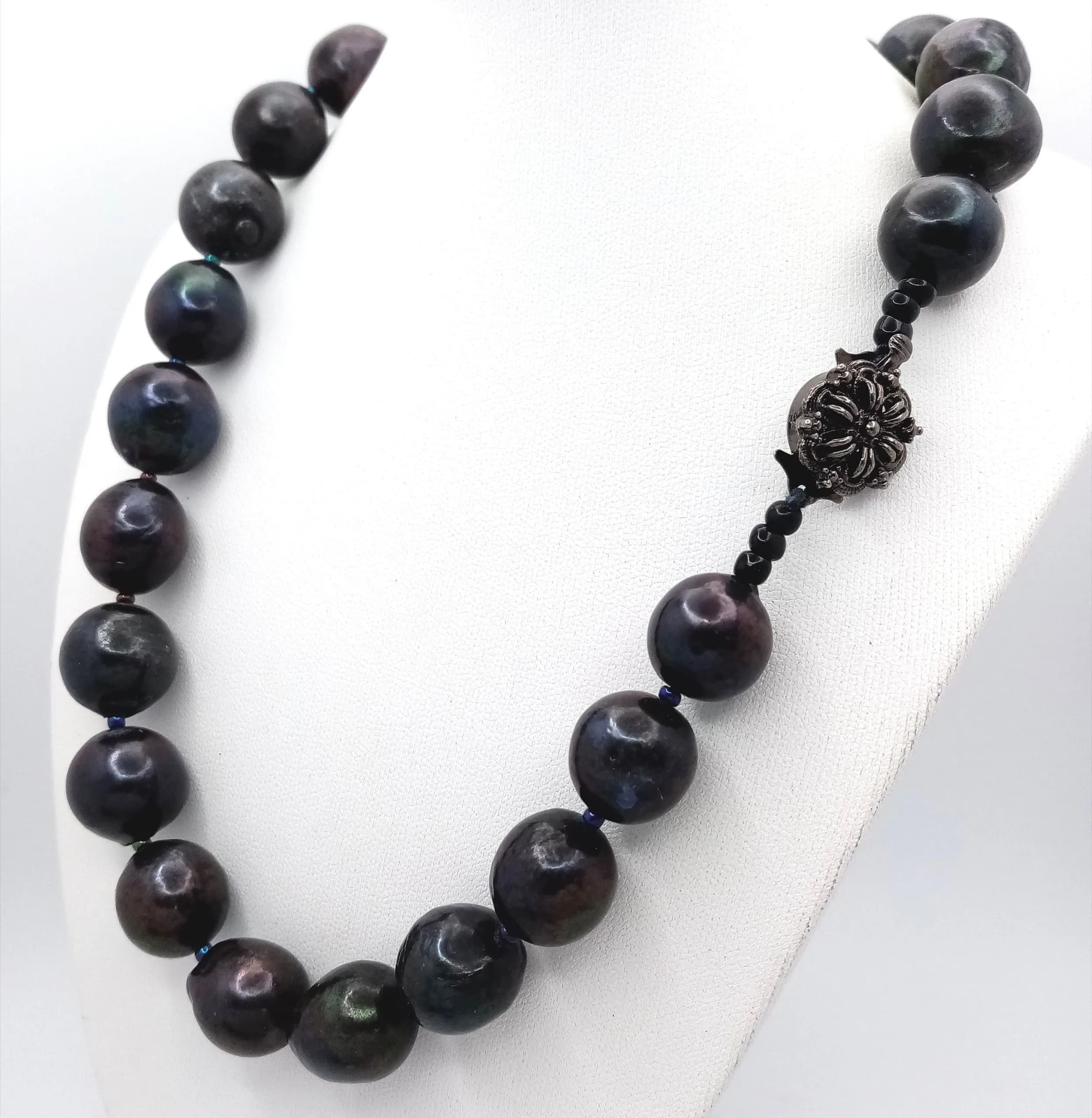 An unique single strand of dark colour Freshwater Pearl Necklace. Approx 44cm in length, strung with large black freshwater pearls and fitted with a decorative floral box clasp.